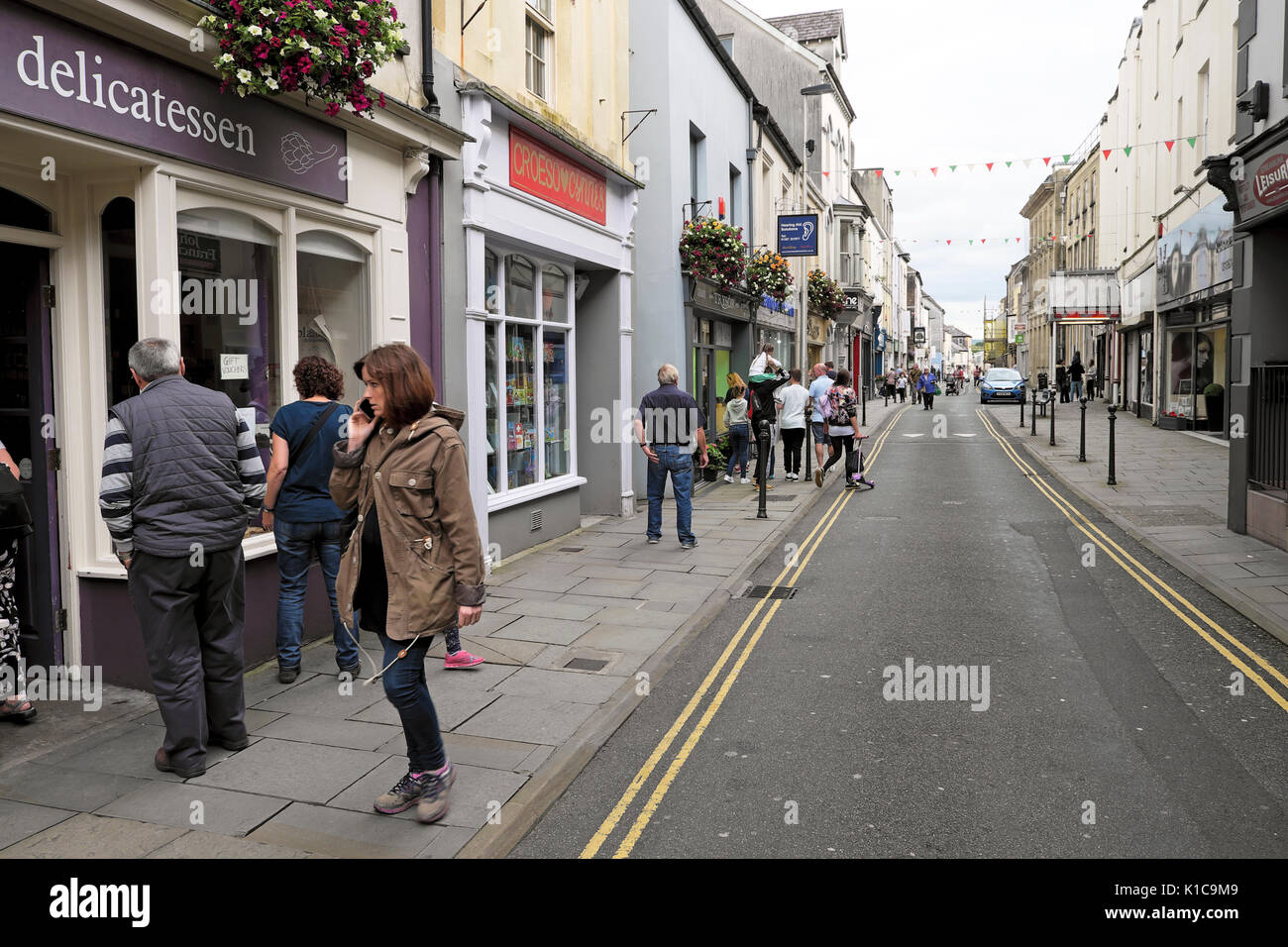 People walking outside a delicatessen in King Street in Carmarthen town, Carmarthenshire, Wales UK    KATHY DEWITT Stock Photo