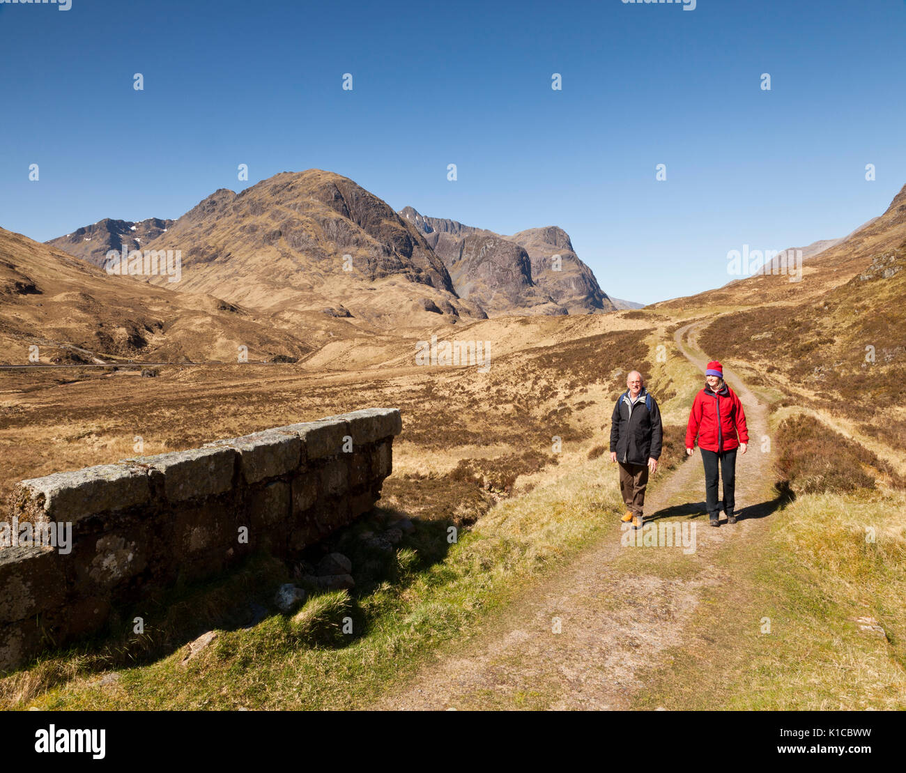 Two walkers hiking in Glencoe, Scotland, UK Stock Photo