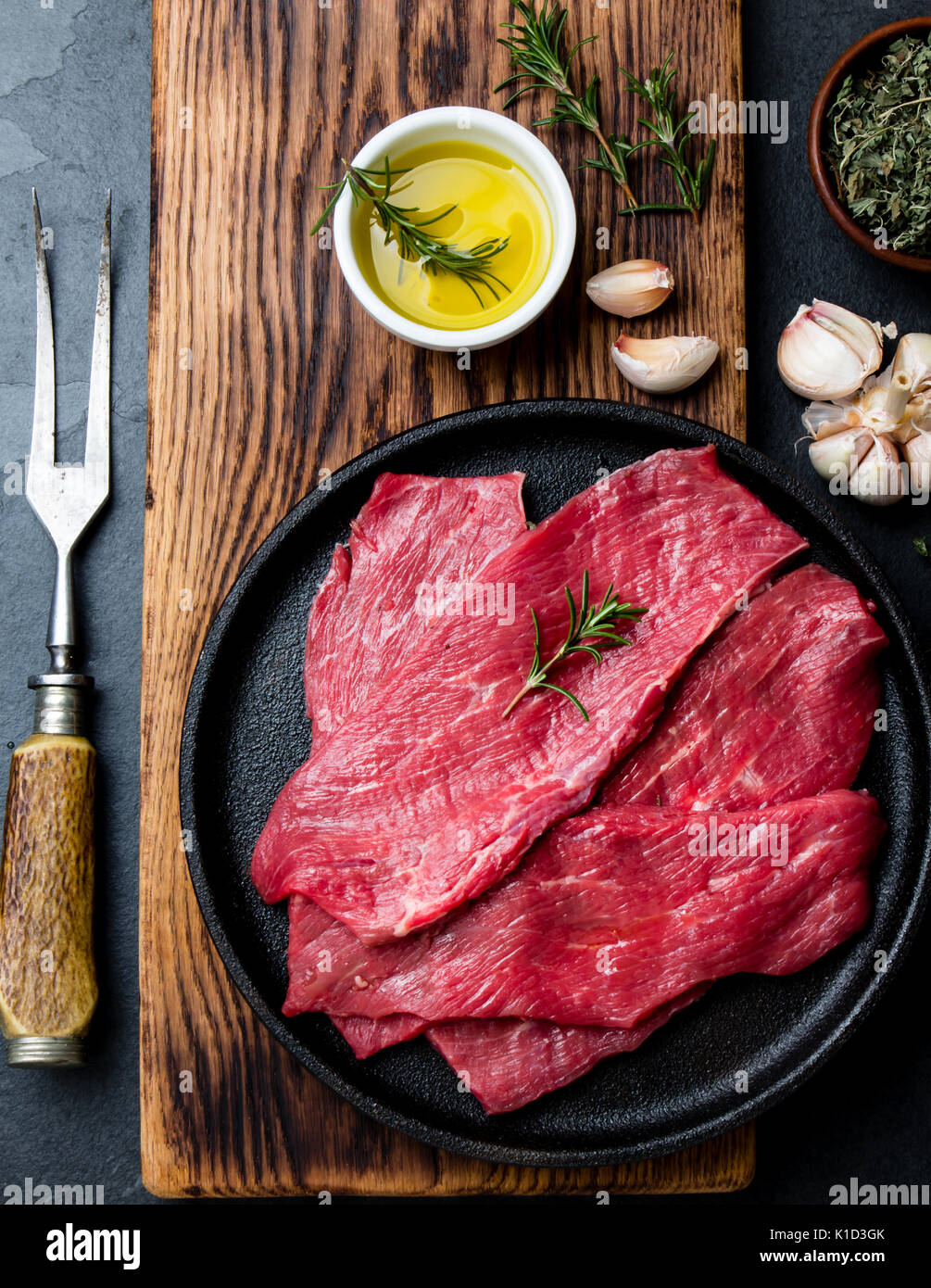 Fresh raw meat beef steaks. Beef tenderloin in cast iron pan on wooden ...
