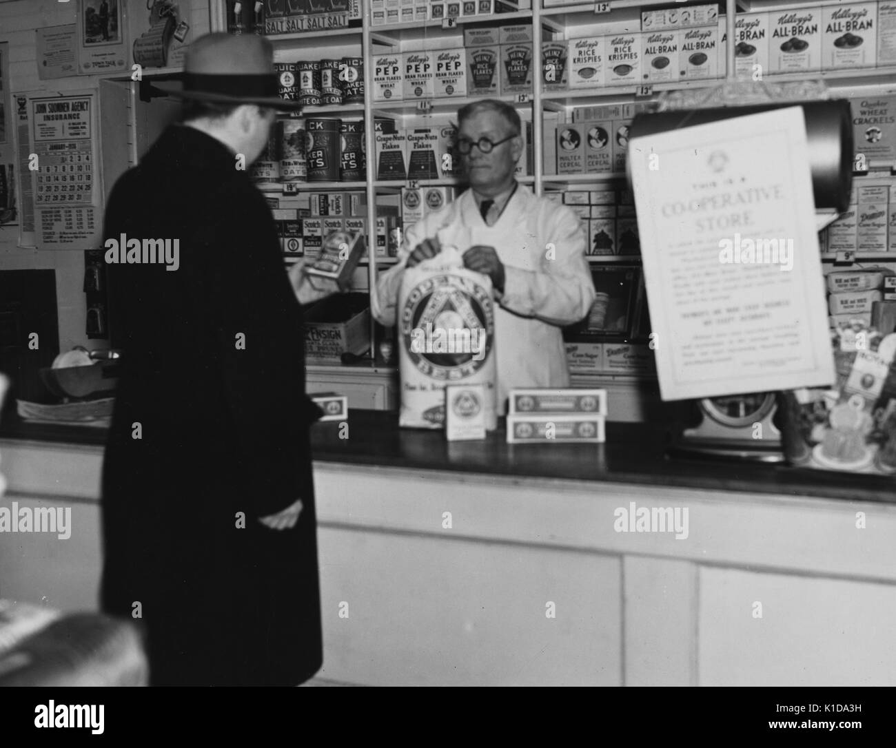 A clerk checks out a man at the United Cooperative store, Fitchburg, Massachusetts, 1936. From the New York Public Library. Stock Photo