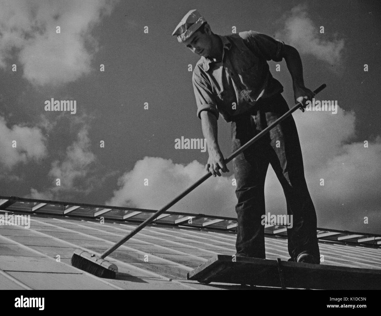 Worker cleaning glass on top of an experimental greenhouse at the United States Department of Agriculture experimental farm, Beltsville, Maryland, 1935. From the New York Public Library. Stock Photo