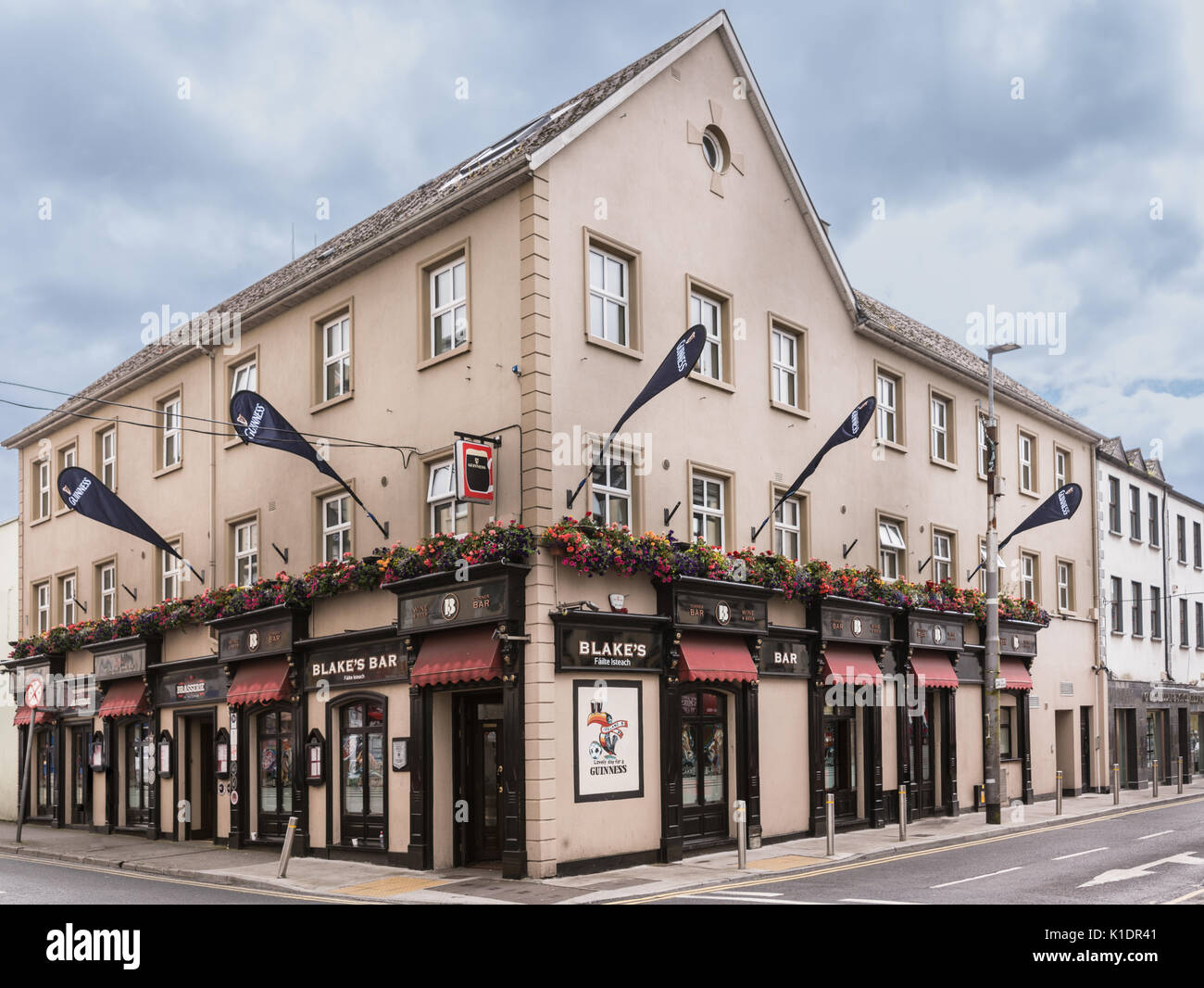Galway, Ireland - August 3, 2017: Historic Blakes Bar and guesthouse two facades on corner with street view. Flowers, flags, awnings and signs. Stock Photo