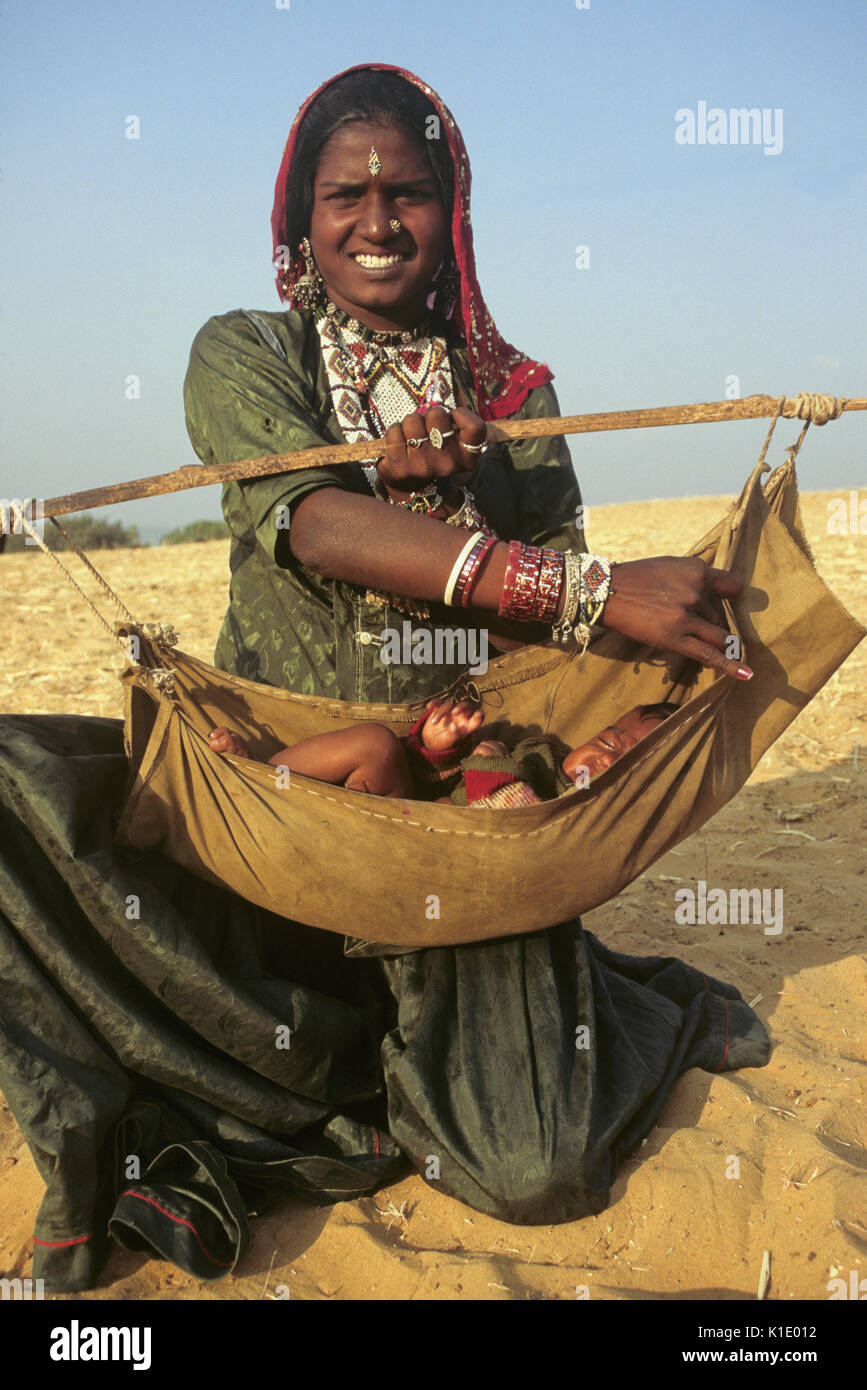 Woman with baby in hammock carrier, Pushkar, Rajasthan, India Stock Photo