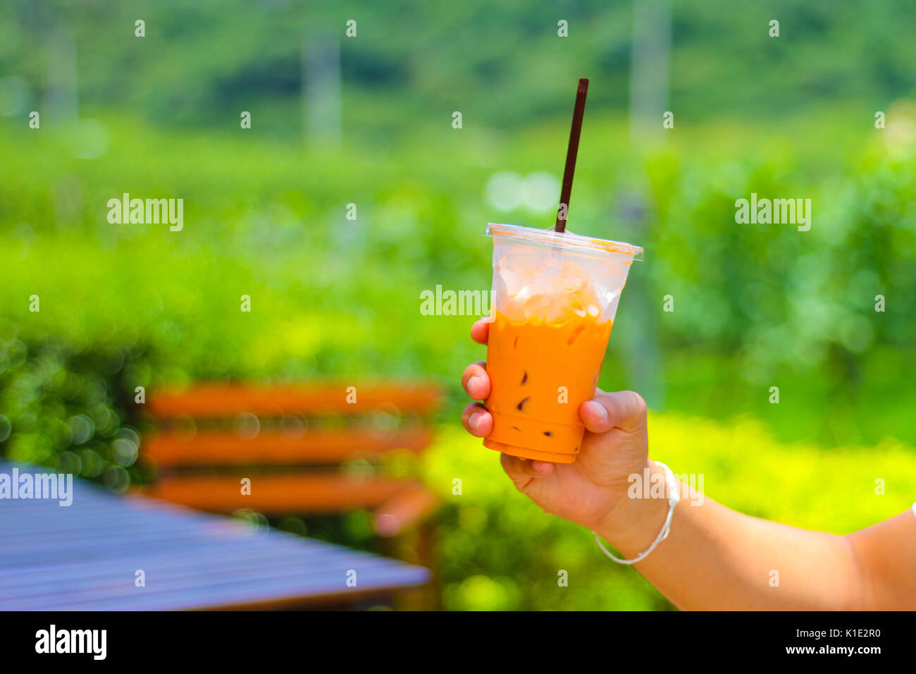 hand with plastic glass of iced tea. Stock Photo