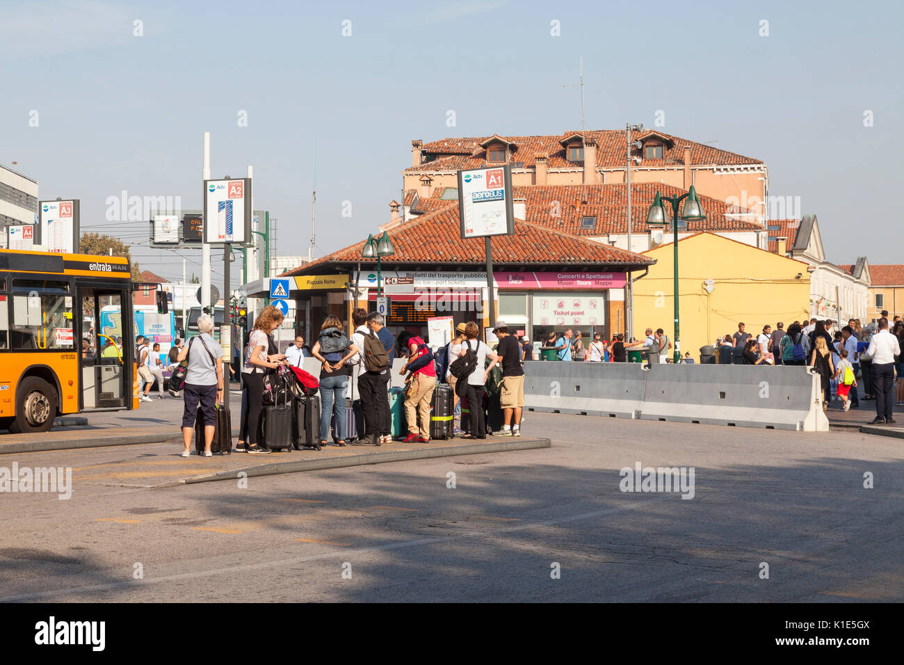 Venice, Italy. 26th Aug, 2017. Anti-terror preparations for the 2017 Venice Film Festival due to start on the 30 August. Overnight the first of the concrete barriers have been installed in the Piazzale Roma to protect pedestrians and the tram lines from vehicular terror attacks. Group of tourists with suitcases waiting to board a bus. Credit: Mary Clarke/Alamy Live News Stock Photo