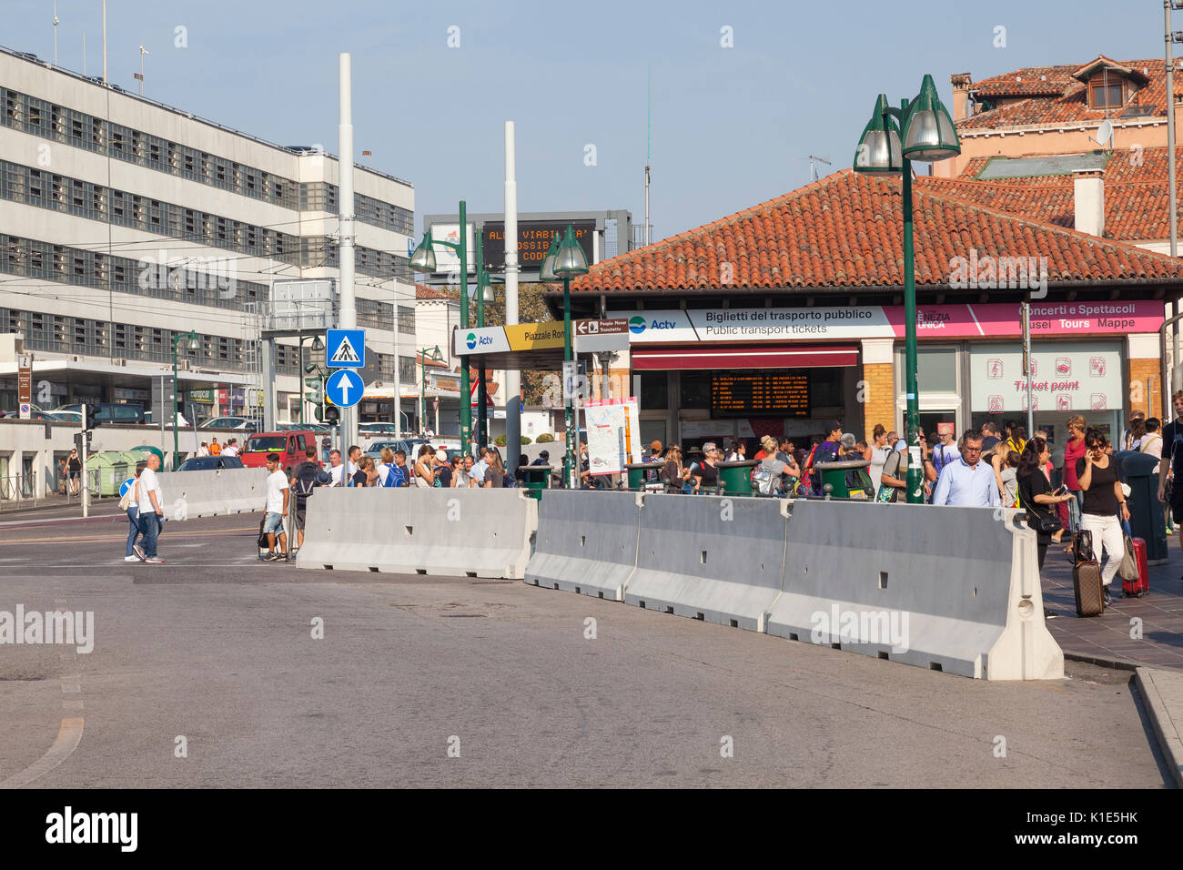 Venice, Italy. 26th Aug, 2017. Anti-terror preparations for the 2017 Venice Film Festival due to start on the 30 August. Overnight the first of the concrete barriers have been installed in the Piazzale Roma to protect pedestrians and the tram lines from vehicular terror attacks. Tourists behind the barrier at the entrance to Ponte della Liberte with the transport ticket office behind. Credit: Mary Clarke/Alamy Live News Stock Photo