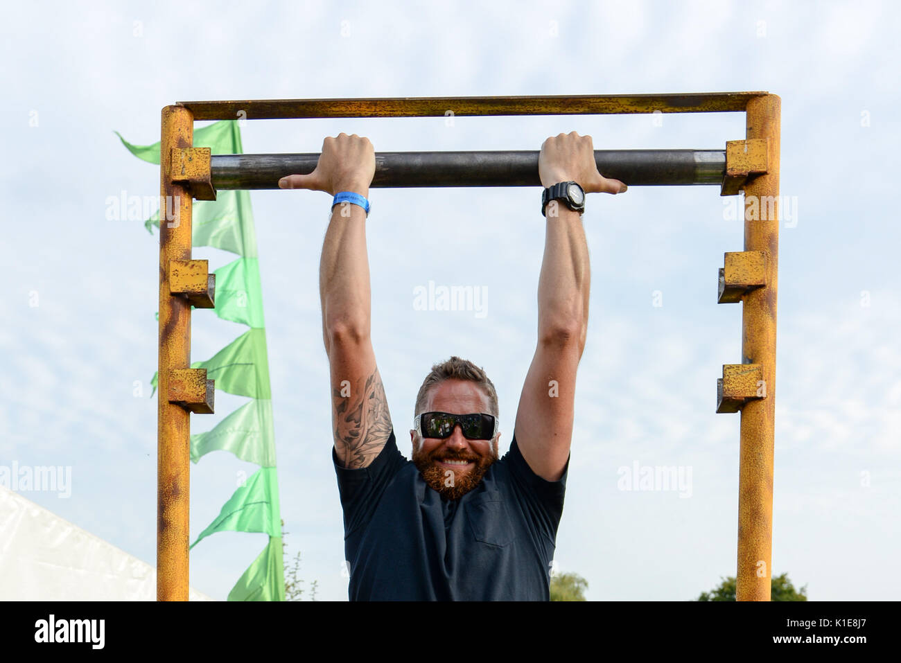 Strong man hanging from a bar Stock Photo Alamy