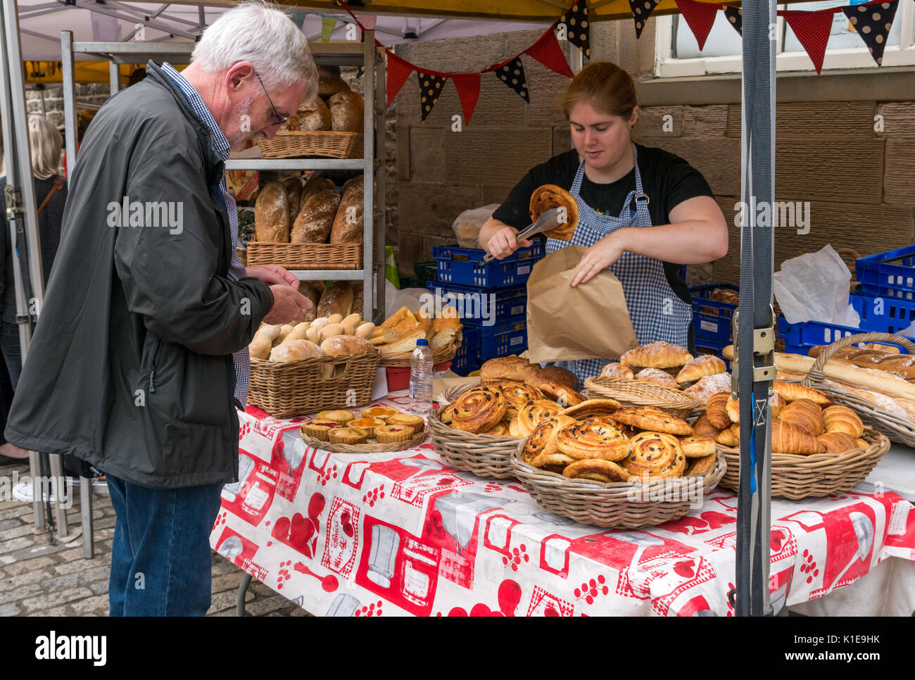 Dock Place, Leith, Edinburgh, Scotland, UK. Food stall at Leith Farmers market, which takes place every Saturday. man buying pain au raisin from Au Gourmand Bread stall Stock Photo