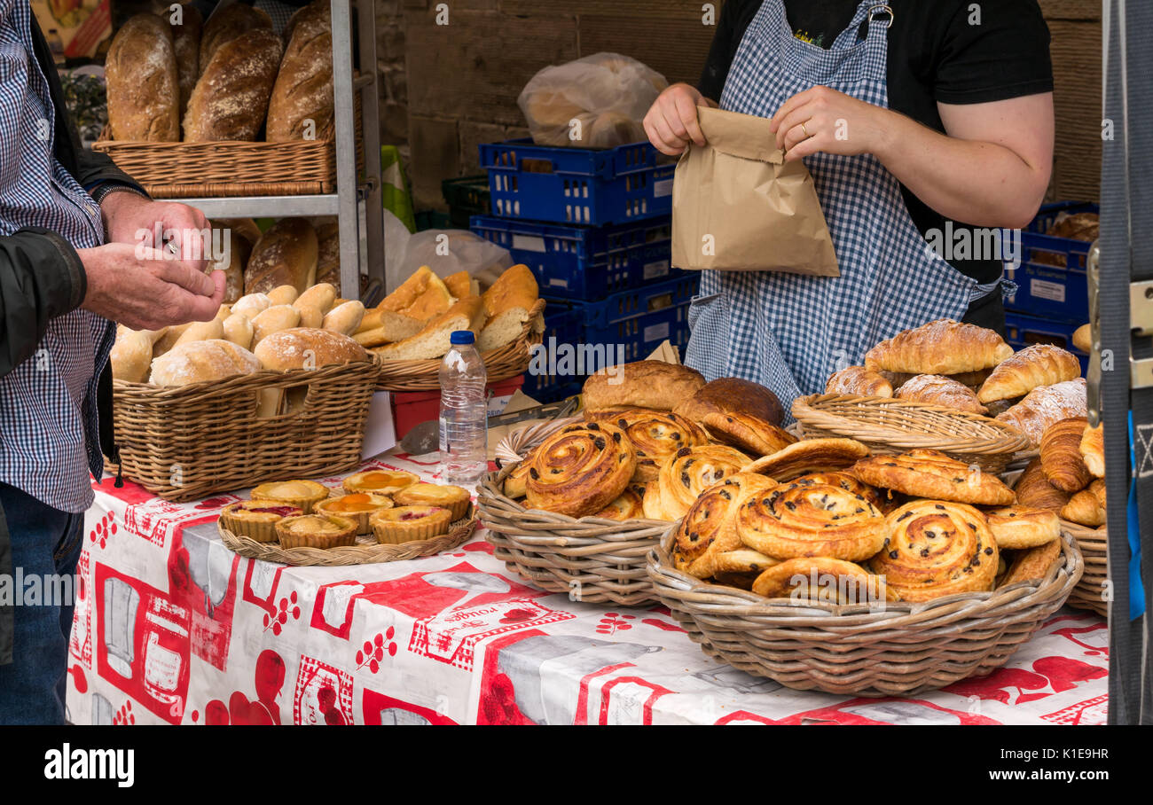 Dock Place, Leith, Edinburgh, Scotland, UK. Food stall at Leith Farmers market, which takes place every Saturday. man buying pain au raisin from Au Gourmand Bread stall Stock Photo