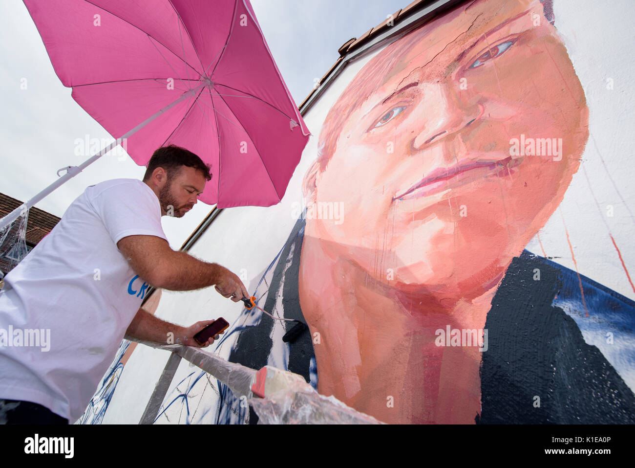 Saarbruecken, Germany. 25th Aug, 2017. Australian street artist Fintan Magee paints the wall of a house in Saarbruecken, Germany, 25 August 2017. The mural is one of 12 artworks created as part of the 'Artwalk'. Photo: Oliver Dietze/dpa/Alamy Live News Stock Photo