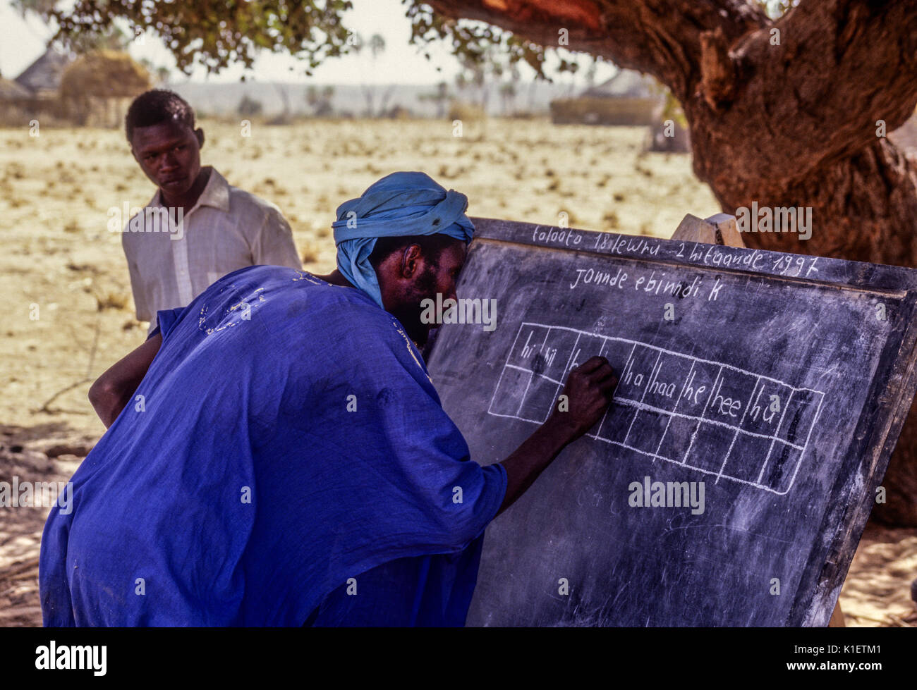 Niger, Doutouel Village, West Africa.  Man Practicing Writing in Adult Literacy Class. Stock Photo