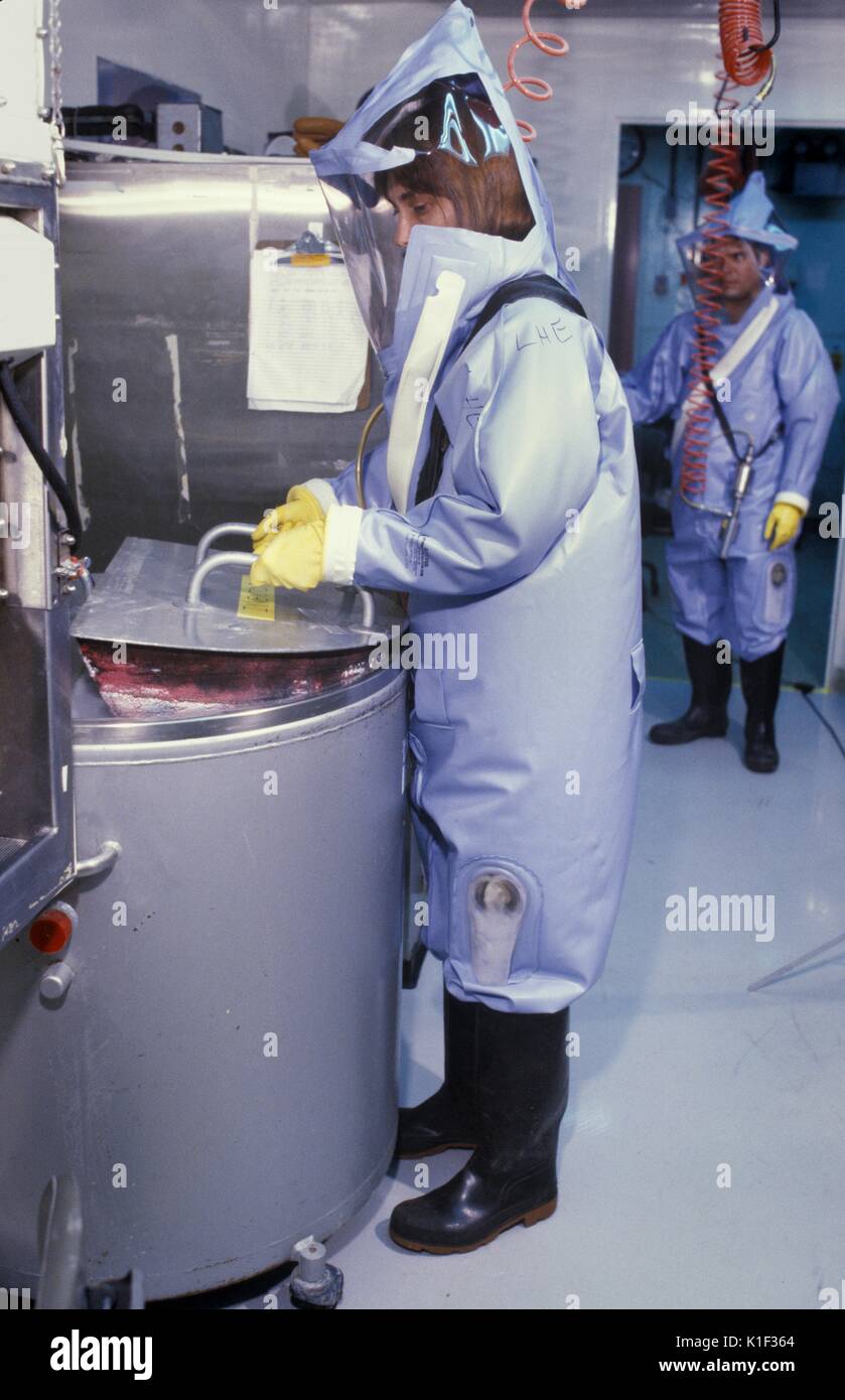 A CDC scientist conducts laboratory research in the Biosafety Level 4 laboratory, Atlanta, GA. LabScience, A CDC scientist wearing a protective suit with helmet and face mask is supplied air via overhead lines that plug into the suit. Image courtesy CDC, 2002. Stock Photo