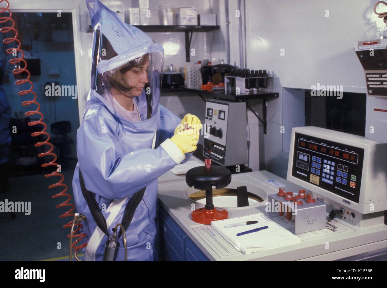 A CDC scientist conducts laboratory research in the Biosafety Level-4 laboratory, Atlanta, GA. LabScience, A CDC scientist wearing a protective suit with helmet and face mask is protected from pathogens as she conducts studies in the CDC BSL-4 laboratory. Image courtesy CDC, 2002. Stock Photo