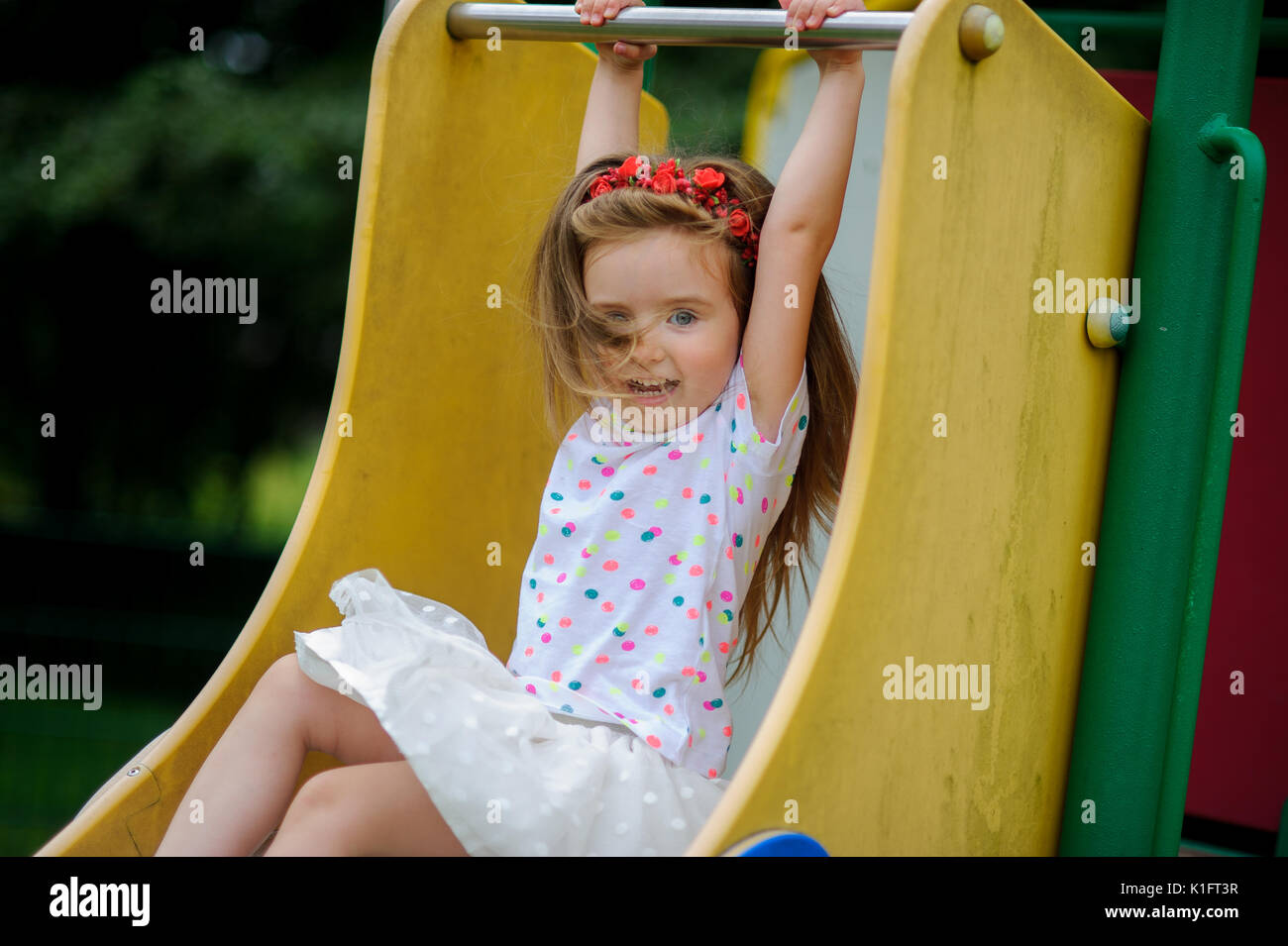 A cute little barefoot girly is playing on the playground. Baby is