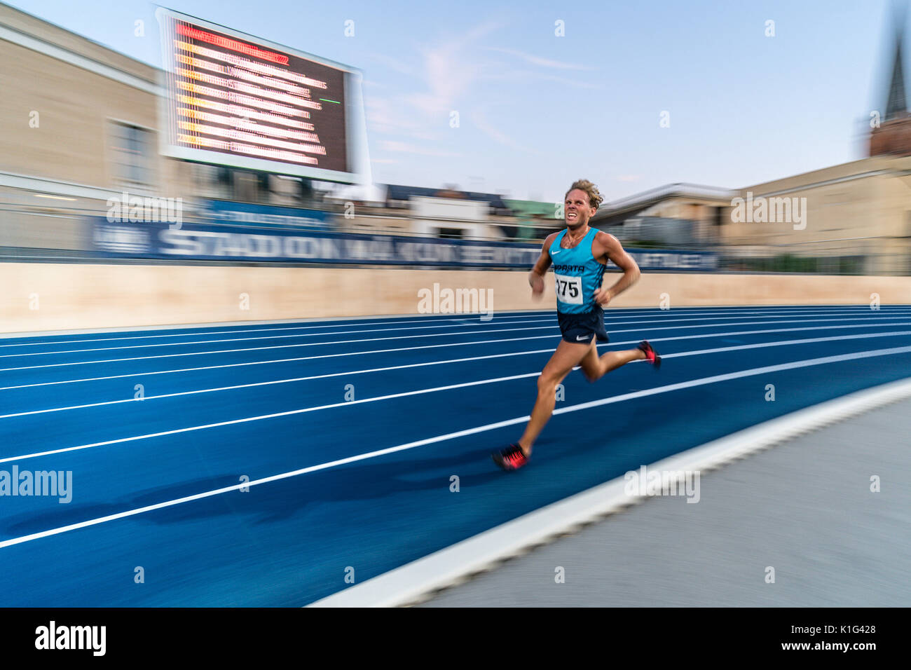 Panning shot of running on the final lap of 5 k track race Stock Photo