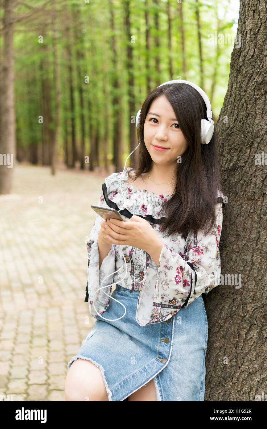 beautiful young Asian girls  in woods listen music Stock Photo