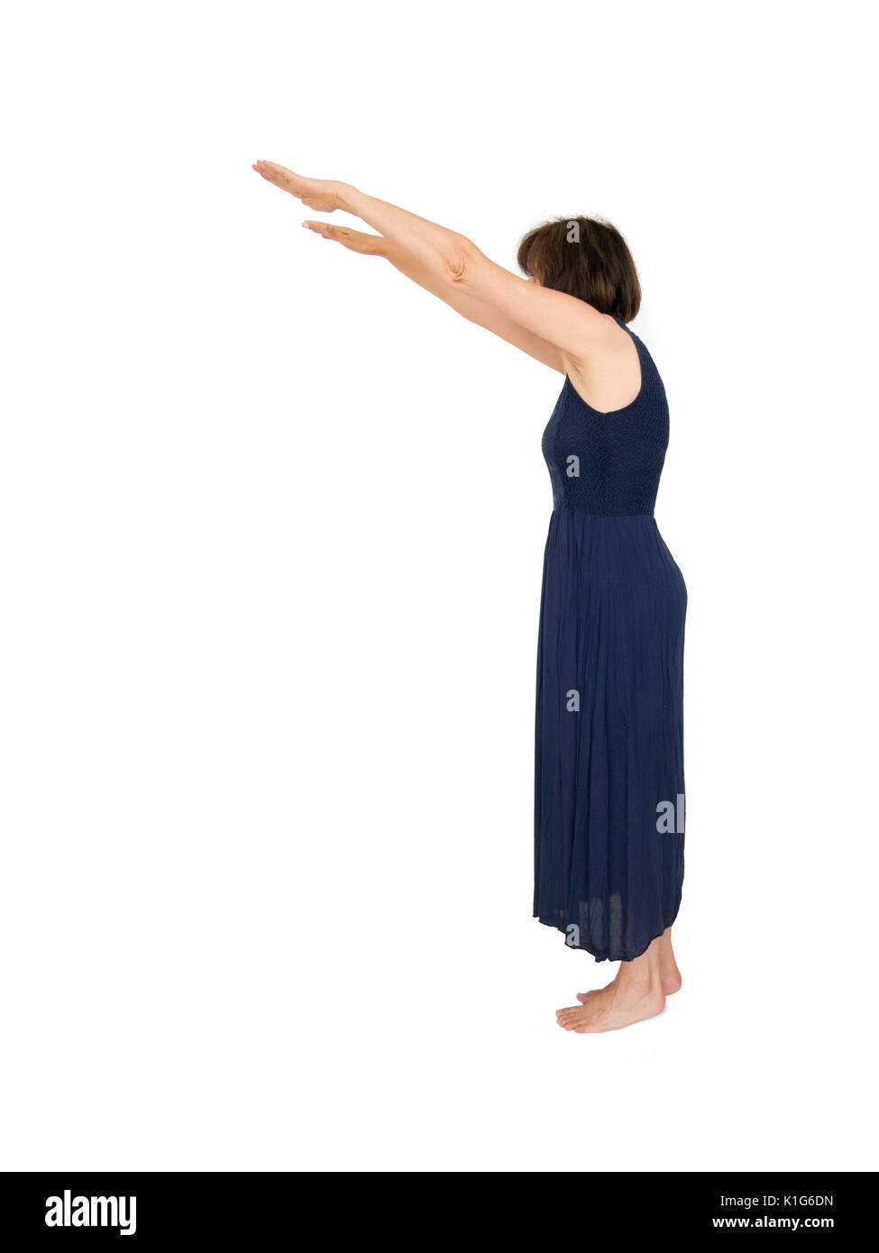 Mature lady with outstretched arms on white. Stretching, exercise maybe. Stock Photo