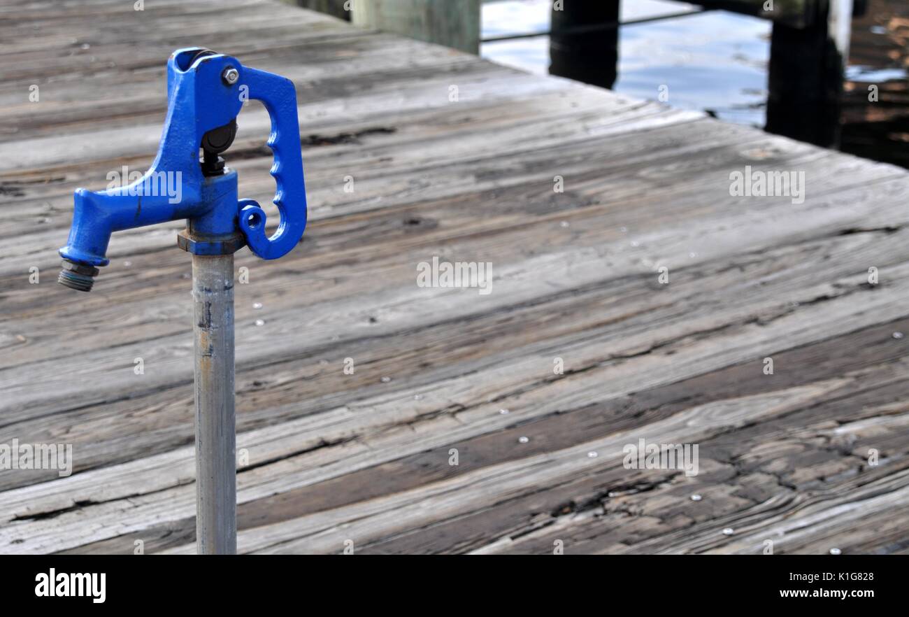 Blue water spigot with handle on a dock with space for text Stock Photo