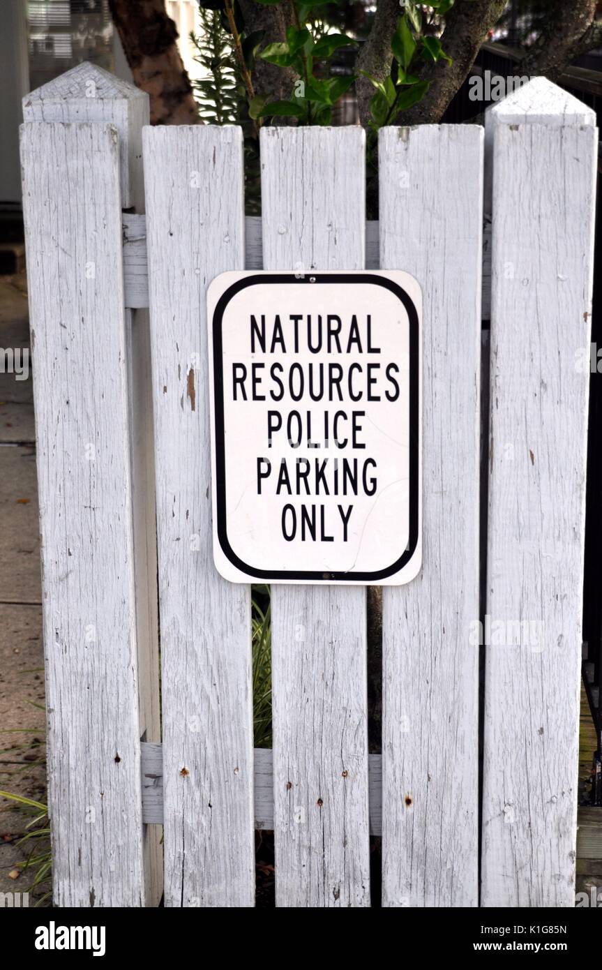 Black and White Natural Resources Police Parking Only sign against a grey fence. Stock Photo