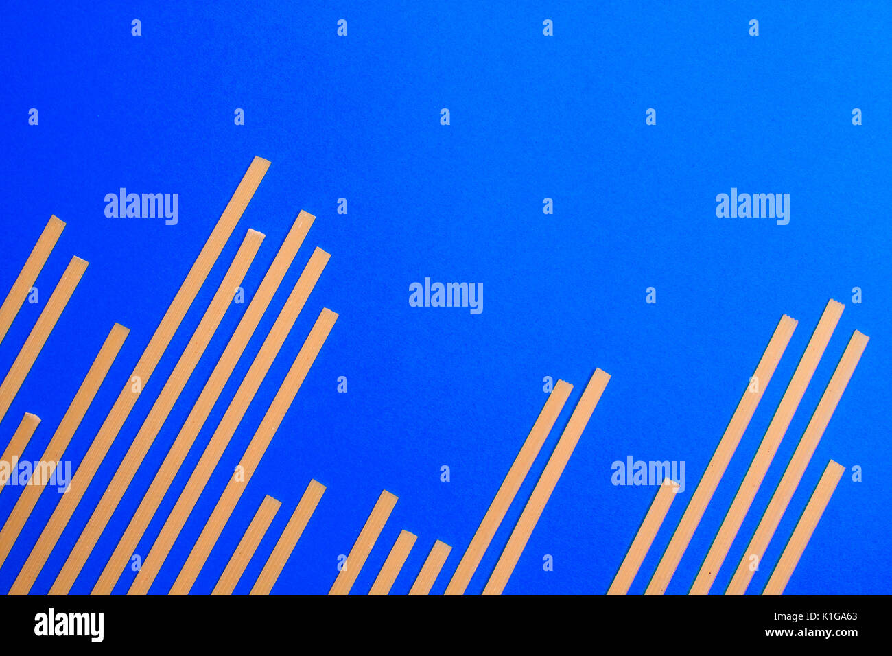 Blue background with yellow long raw pasta arranged in bar graph Stock ...