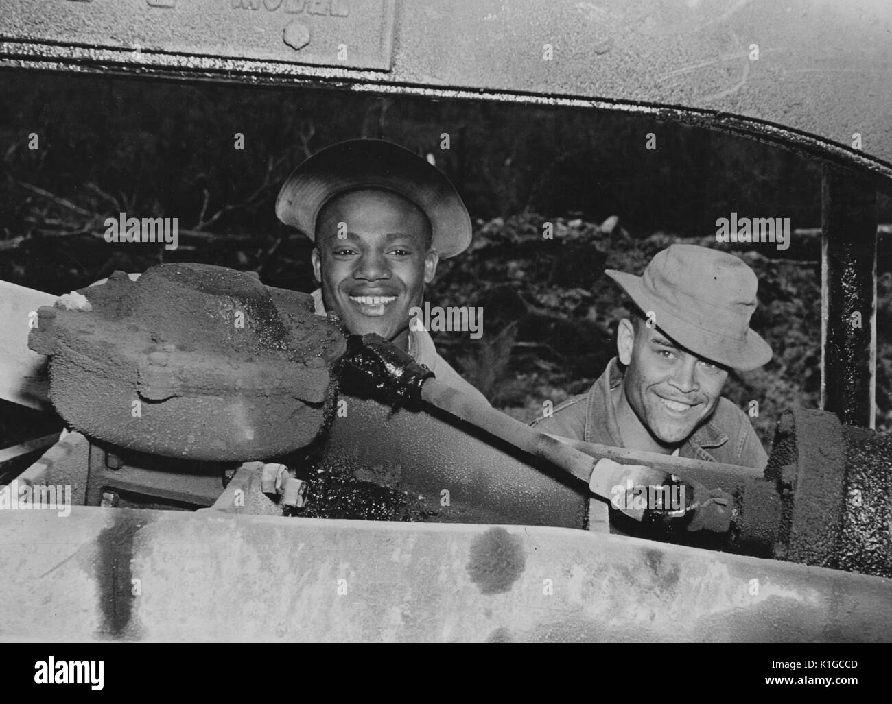 Two soldiers, Private James A Jackson of Kearneysville, West Virginia, and Private First Class Willie Lee Jell, of Baton Rouge, Louisiana, making repairs on a motor grader, 1942. From the New York Public Library. Stock Photo
