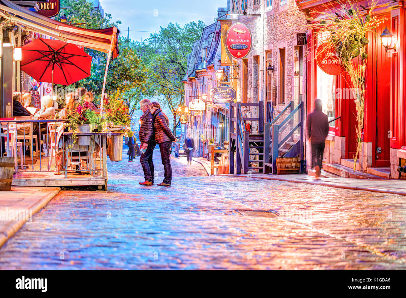 Quebec City, Canada - May 31, 2017: Lower old town cobblestone street Sous le Fort with restaurants and Boutique La Chasse-galerie at night and couple Stock Photo