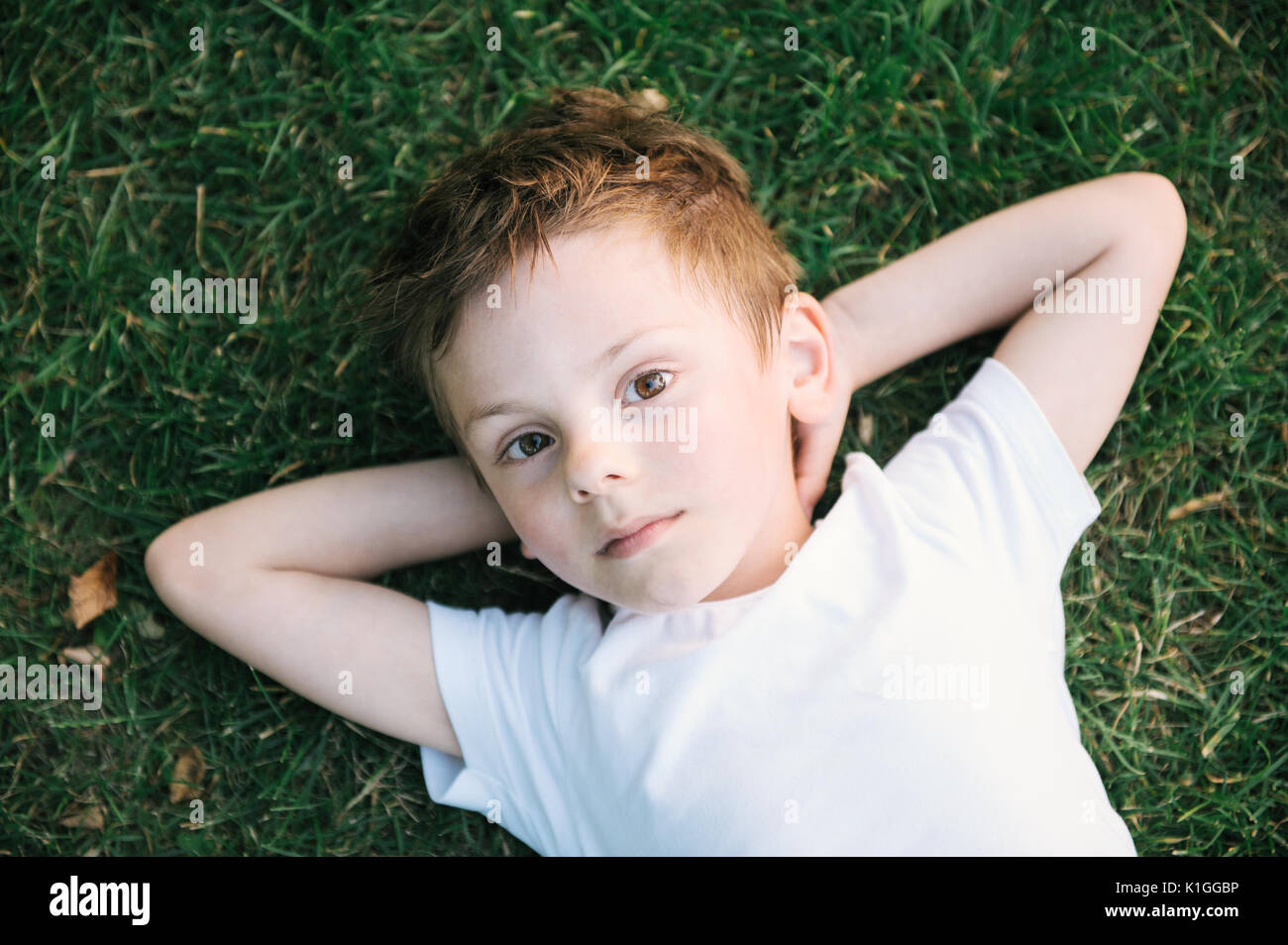 cute little irish kid relaxing lying on green grass Stock Photo Alamy