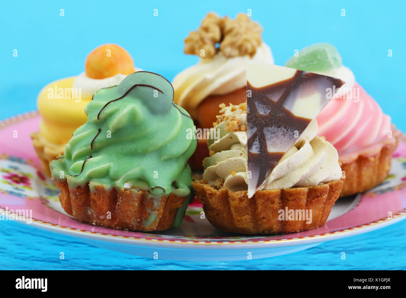 Selection of delicious cream cakes on vivid blue background Stock Photo