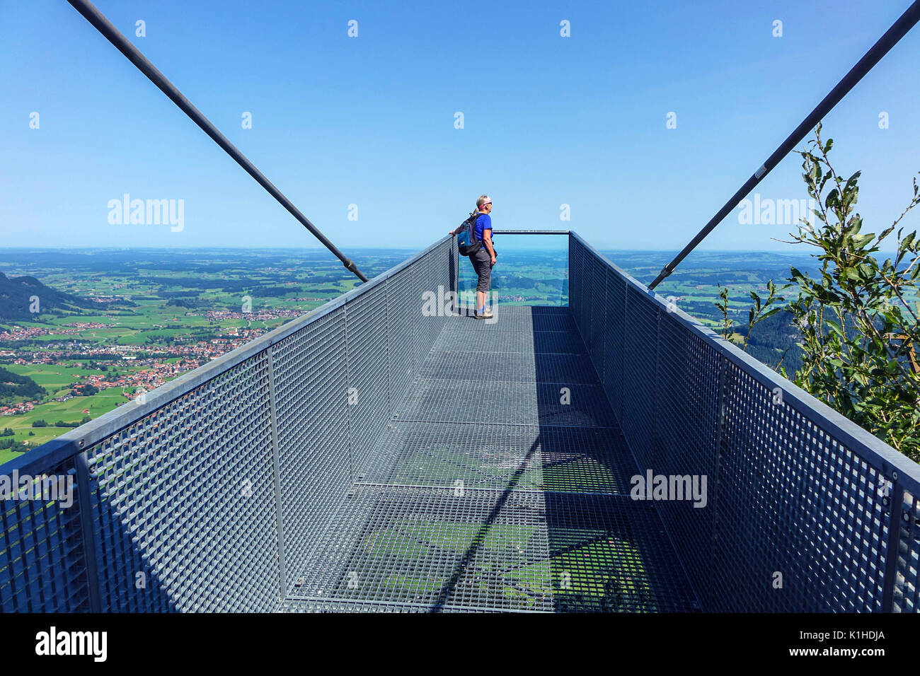 Solitary female figure on walkway viewpoint above Skigebiet Breitenberg-Hochalpe cable car, Pfronten, Bavaria, Germany Stock Photo