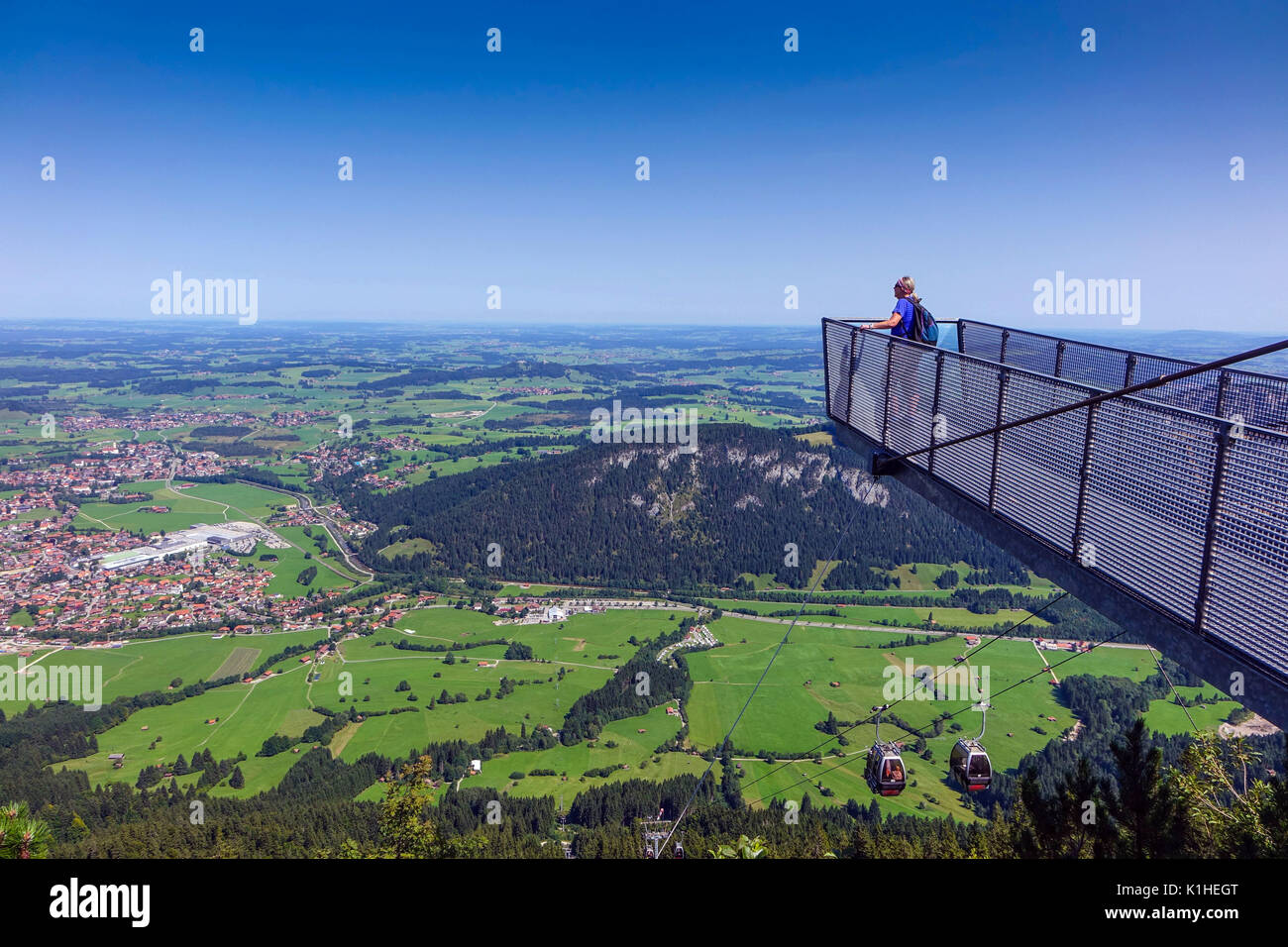 Solitary female figure on walkway viewpoint above Skigebiet Breitenberg-Hochalpe cable car, Pfronten, Bavaria, Germany Stock Photo