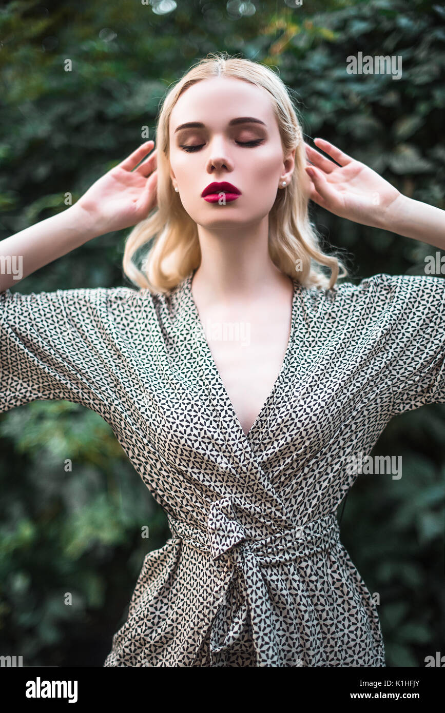 young beautiful blond girl with red lipstick in her big bright eyes and ...