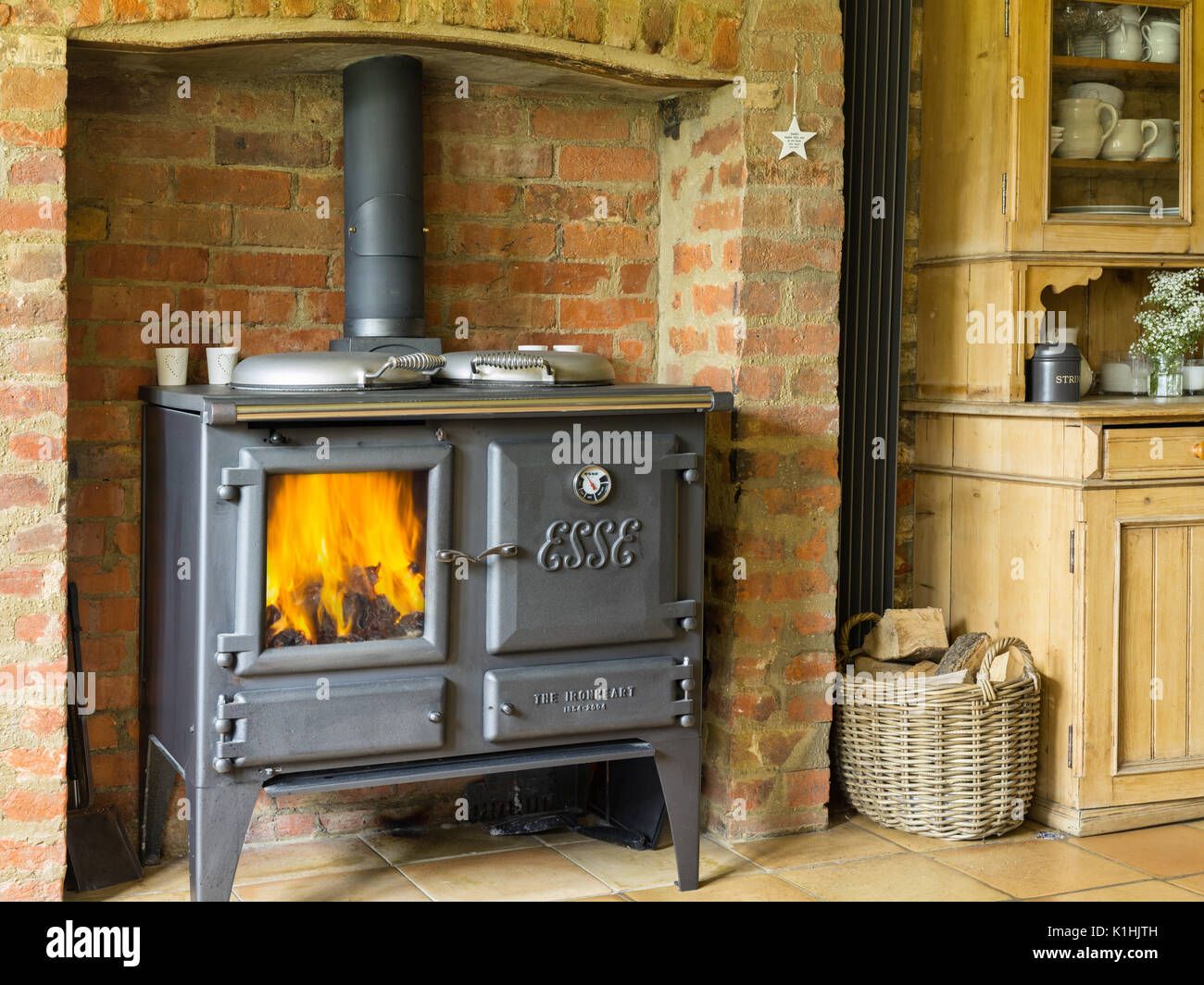 A cast iron Esse Ironheart wood burning stove, alight in a British country kitchen. Stock Photo