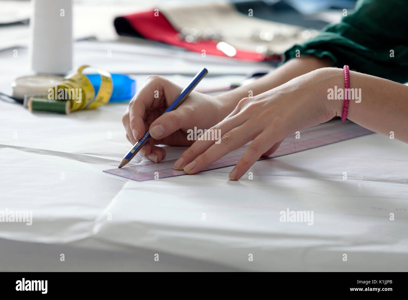 Female fashion designer is sketching a new concept in fashion school's ...
