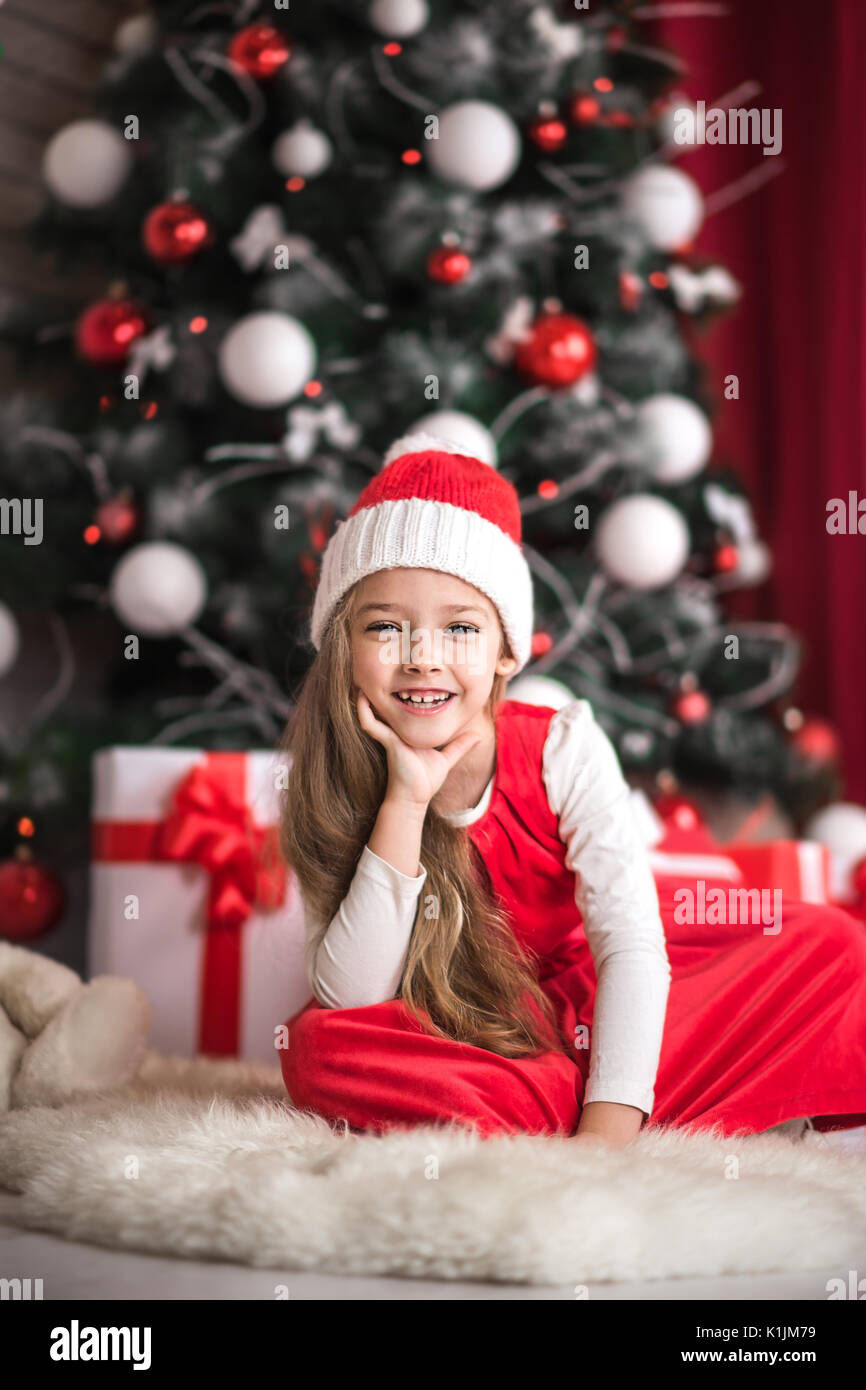 Portrait of a cute little girl on a christmas tree background, studio ...