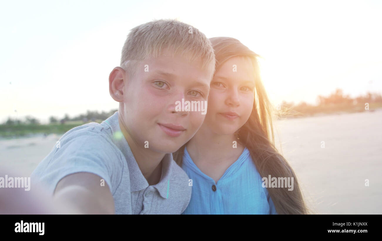 Little boy and girl of 8 - 10 years old making selfie using smartphone. Kids on vacation or holidays in summer. Stock Photo