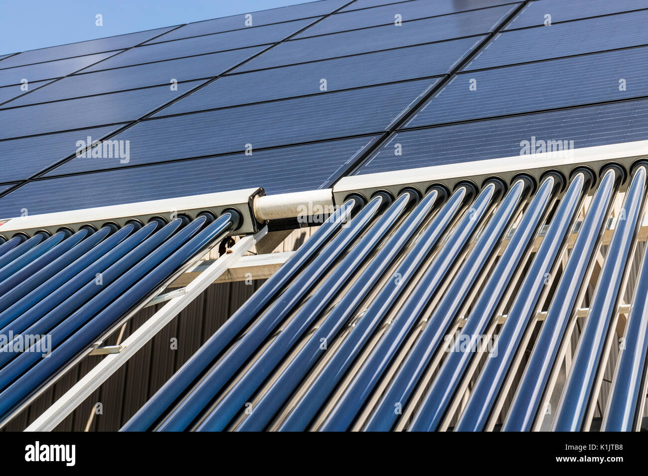 Solar Thermal Flat Panels with Evacuated Tube Collectors. Many companies are installing renewable energy sources to reduce their carbon footprint III Stock Photo