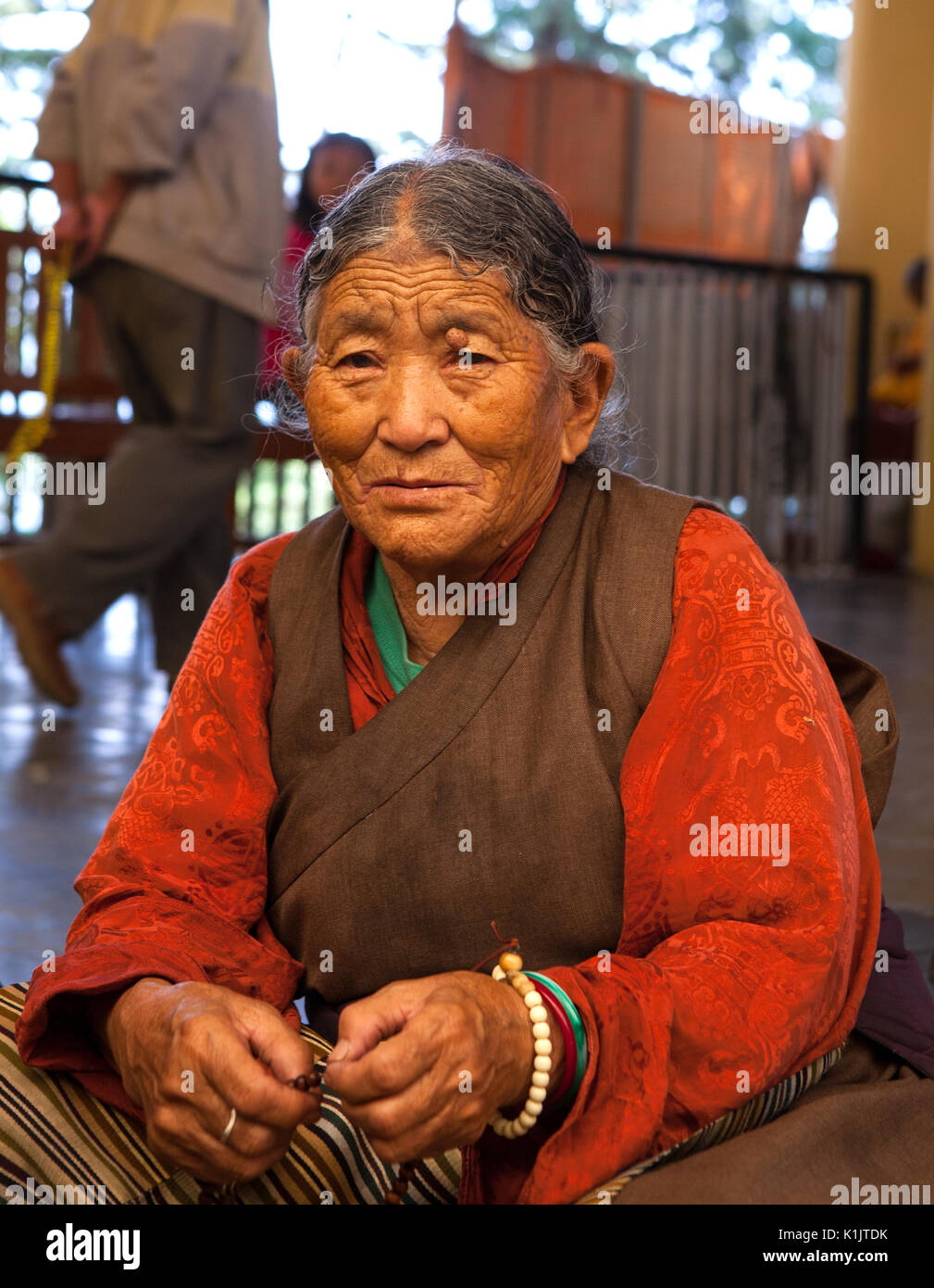 Closeup portrait of an elderly female pilgrim-Buddhist  about the Tsuglakhang monastery near the residence of His Holiness the Dalai Lama XIV. Stock Photo