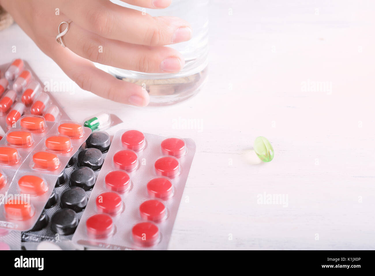 Close-up of woman hands with glass of water, pills and tablets. Healthcare concept. Stock Photo