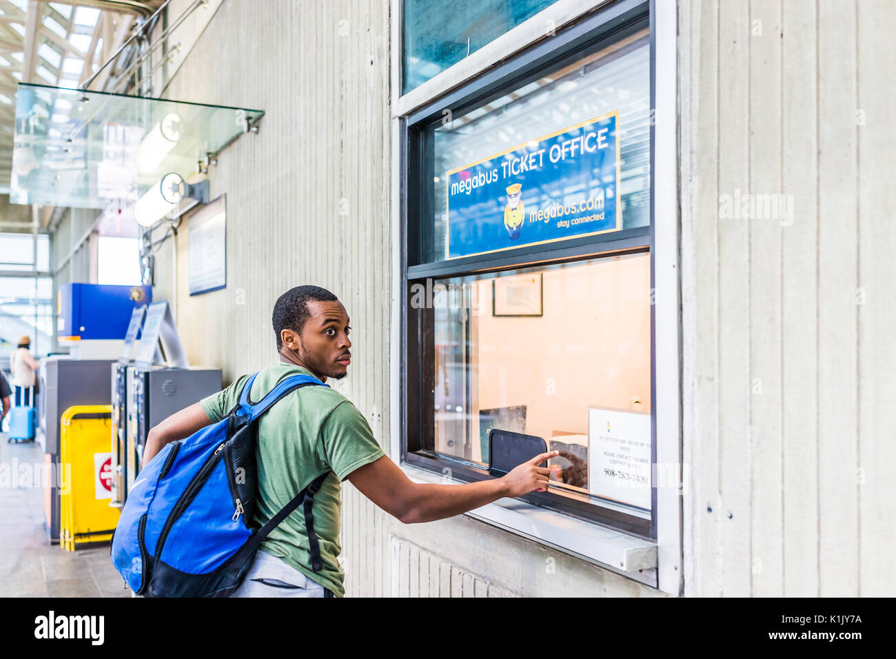 Washington DC, USA - July 1, 2017: Inside Union Station in capital city with young man at bus ticket booth Stock Photo