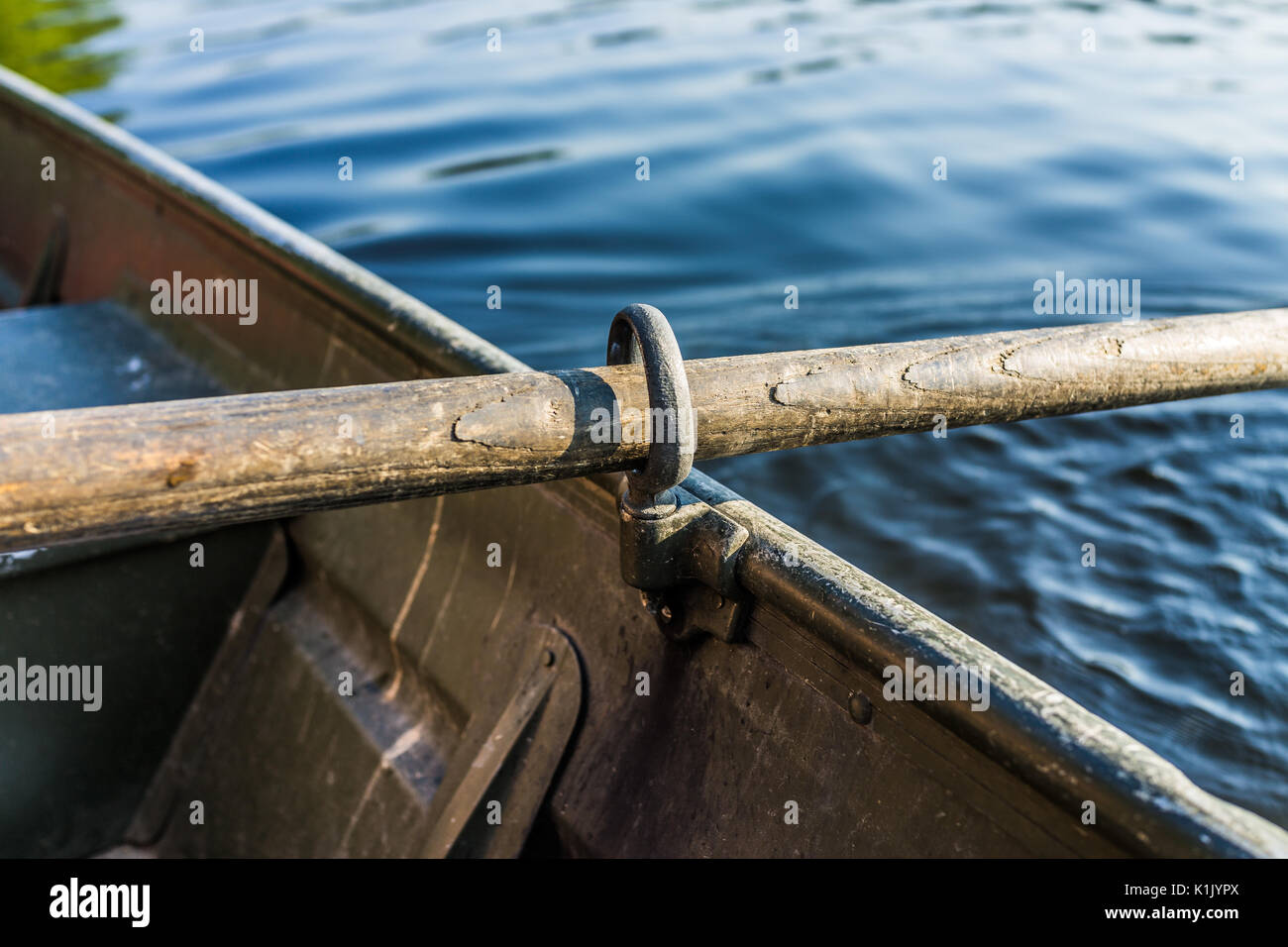 Row boat oar lock closeup in hole during summer with water Stock Photo