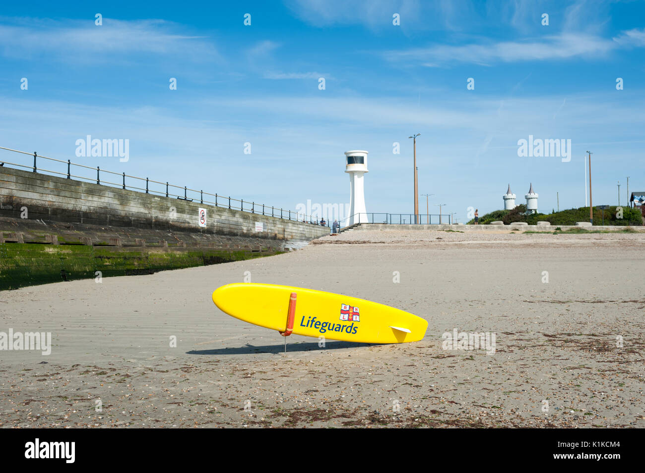 a-yellow-rnli-lifeguard-paddle-board-or-surfboard-in-front-of-a