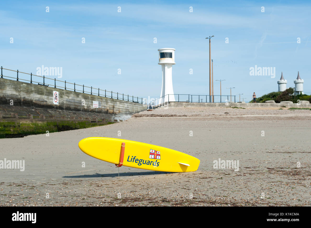 a-yellow-rnli-lifeguard-paddle-board-or-surfboard-in-front-of-a
