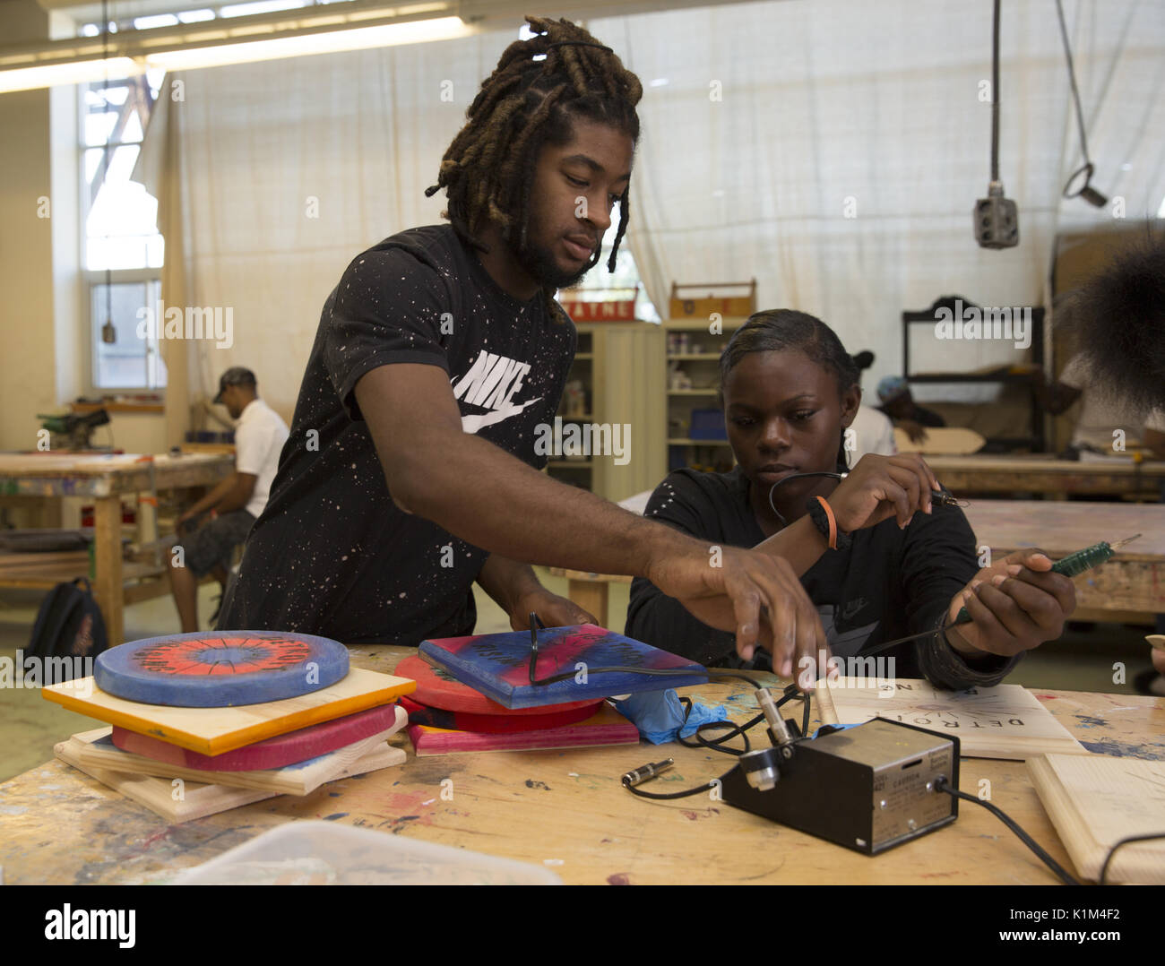 Students from the Detroit Community School participate in a motivational summer paid work program where they learn life, work and business skills in an entrepreneurial incubator type environment. Woodworking & sign shop. Stock Photo