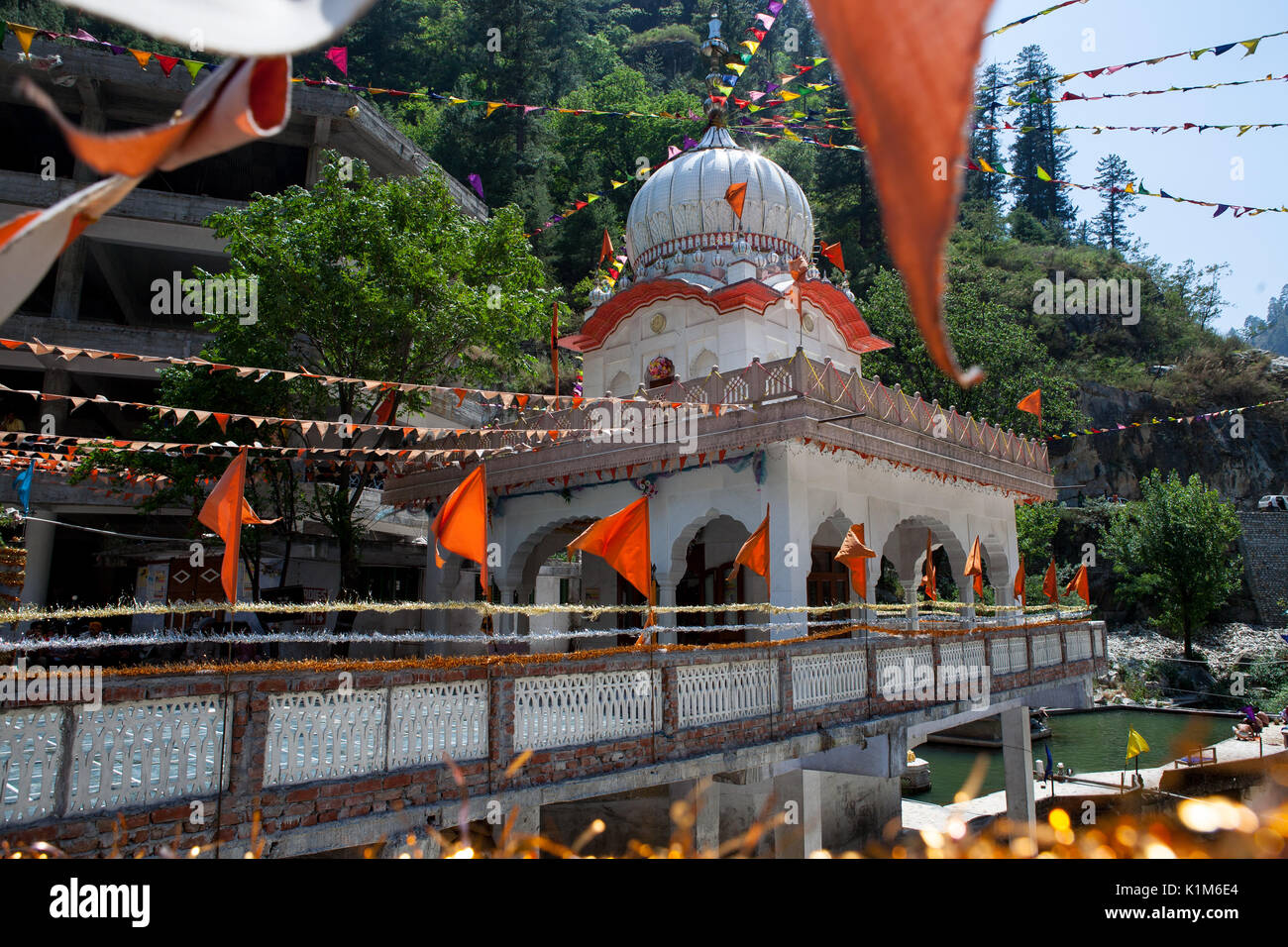 Sacred prayer flags and a bridge across the river Parvati in the Himalayas. Stock Photo