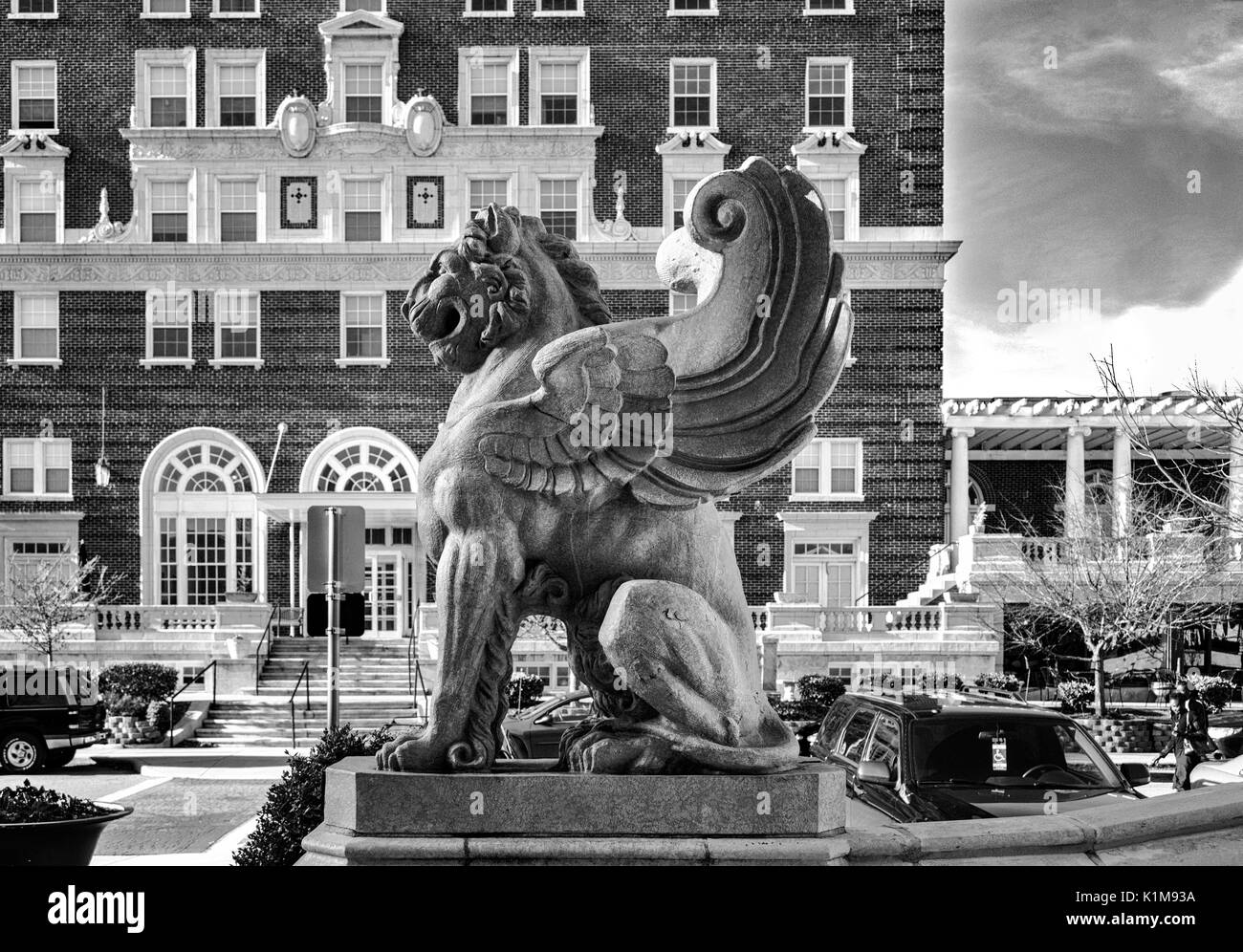 A winged lion statue from the Grove Arcade in profile, with the Battery Park Hotel in the background, in Asheville, North Carolina Stock Photo