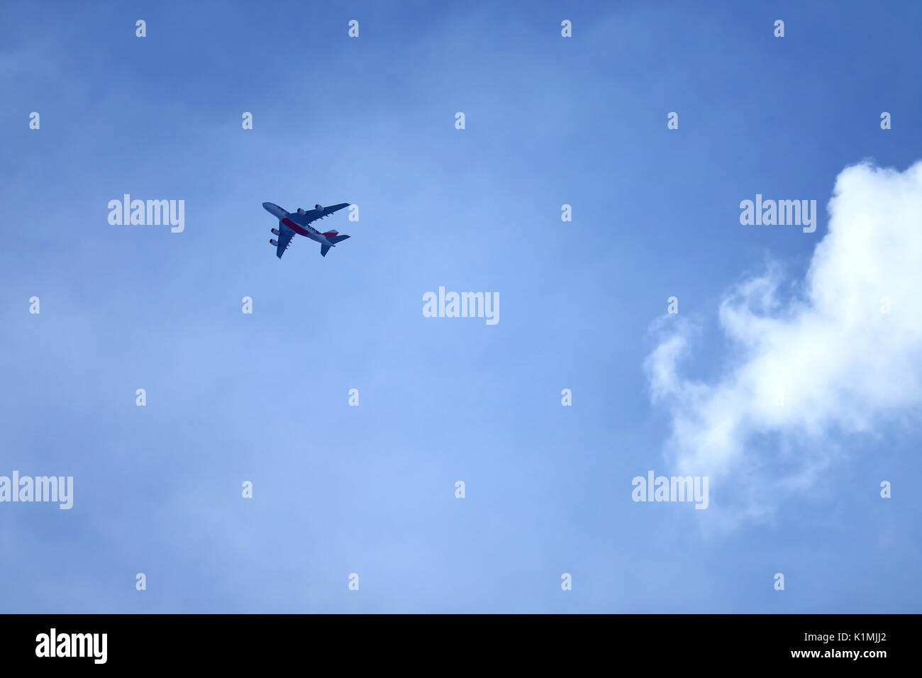 Flying airplane on blue sky with pure white cumulus cloud Stock Photo ...