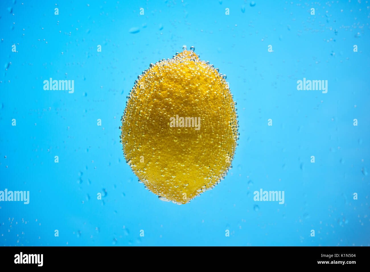 Yellow lemon floating in water shot Stock Photo Alamy