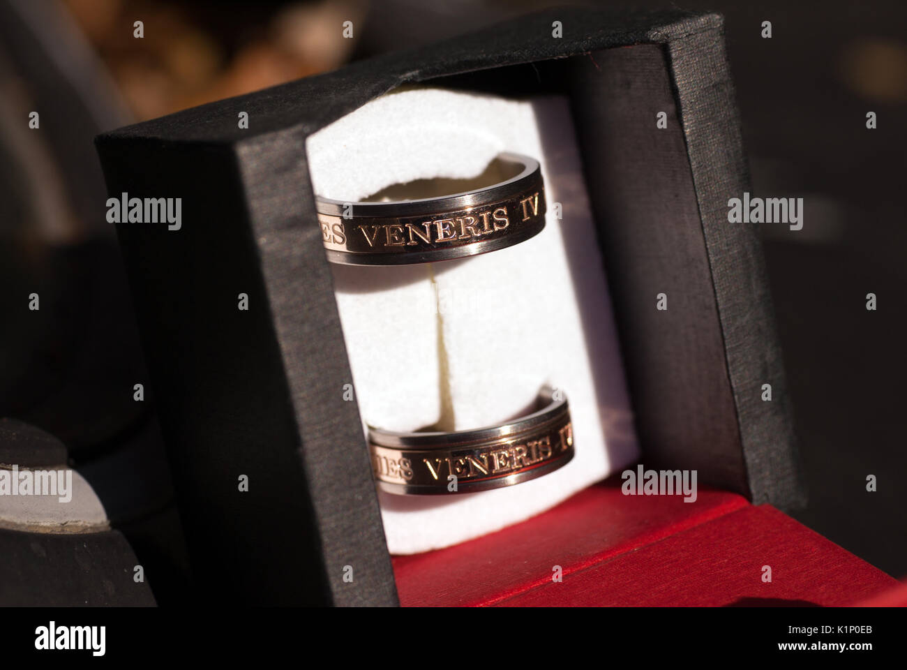 Matching titanium rings with a rose gold inlay engraved with the date Stock Photo