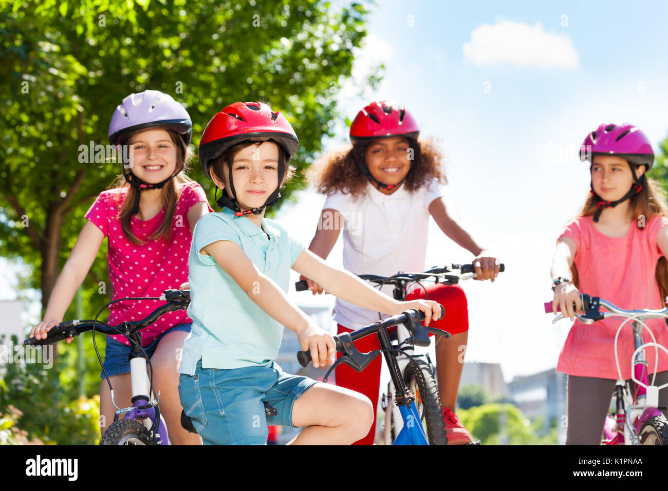 Portrait of happy five years old boy riding bicycle with his friends in