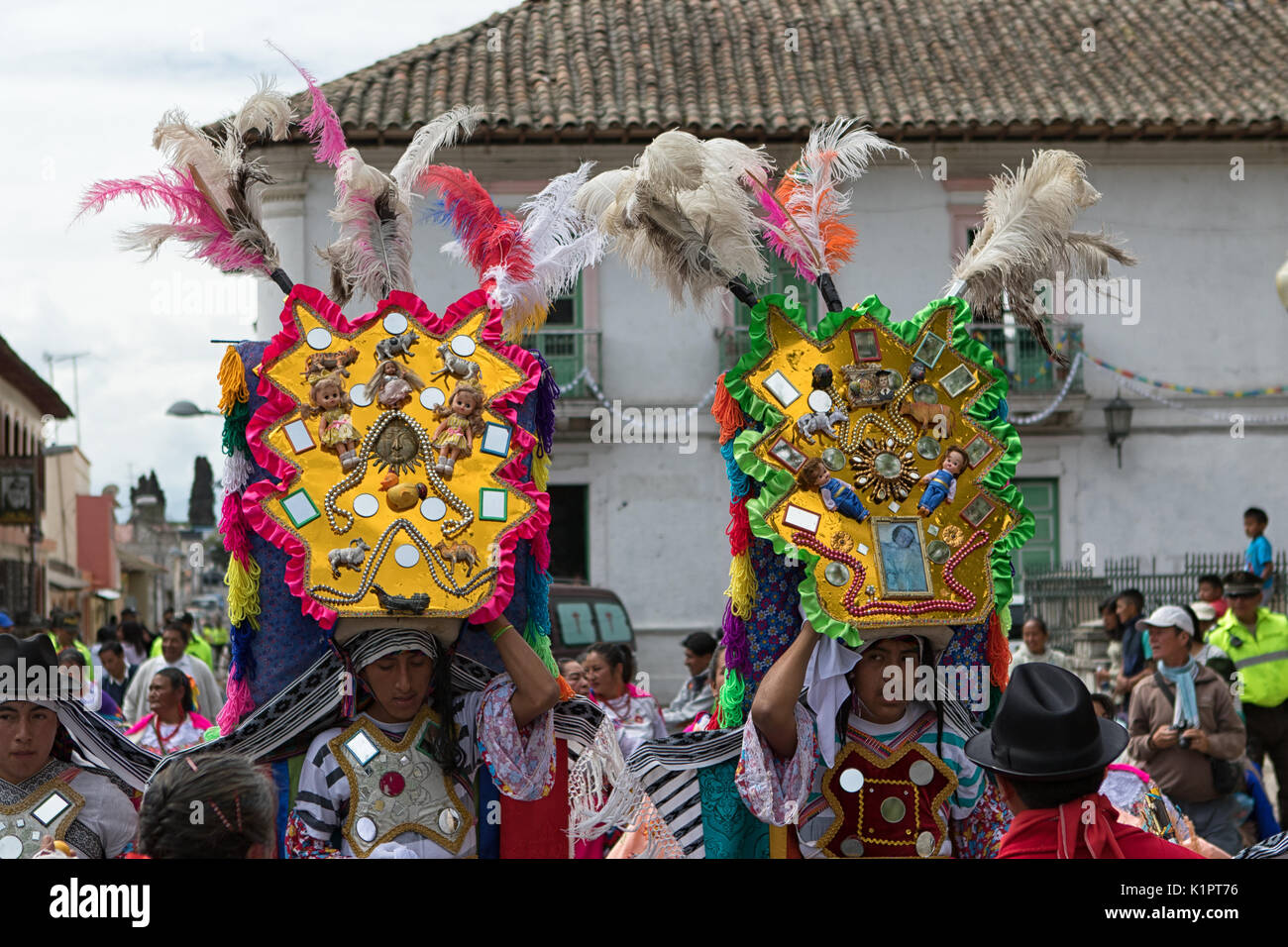 June 18, 2017 Pujili, Ecuador: indigenous kichwa men in colourful costume balancing a large display on his head at Corpus Christi parade Stock Photo